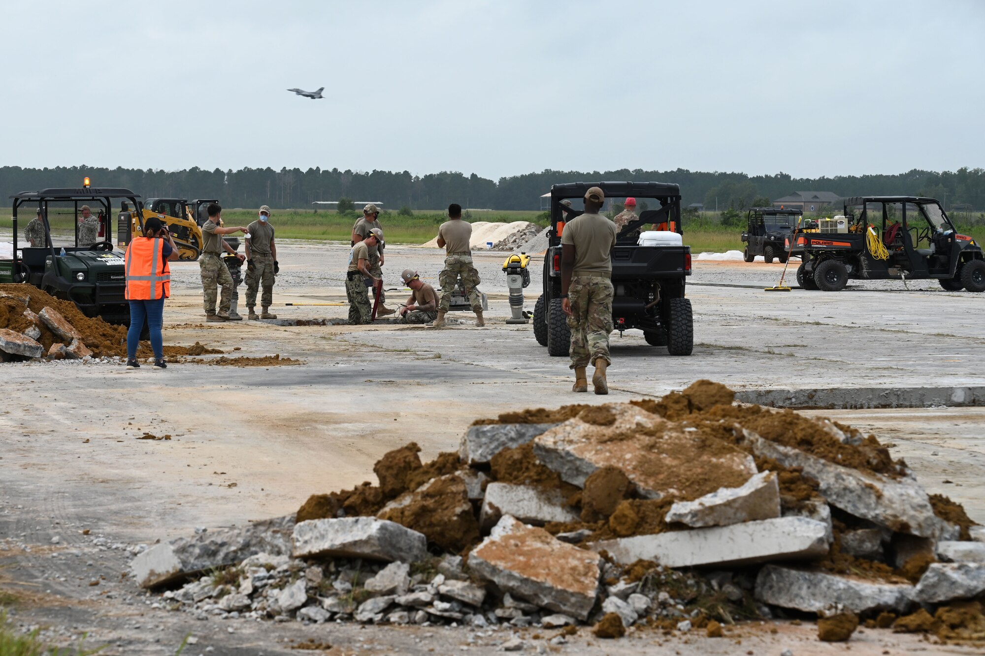 U.S. Air Force civil engineers from the pavements and construction equipment career field, known as the Dirt Boys from eight separate units, team up with U.S. Navy Seabees from the Naval Mobile Construction Battalion 133, Gulfport, Mississippi for an Expedient and Expeditionary Airfield Damage Repair (E-ADR) demonstration at McEntire Joint National Guard Base, South Carolina, Aug. 27, 2021. The purpose of the training is to provide just enough, just in time repair capability with minimal cost and materials in a wartime situation.  (U.S. Air National Guard photo by Senior Master Sgt. Edward Snyder, 169th Fighter Wing Public Affairs)
