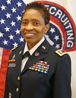 women in u.s. army uniform standing in front of flags