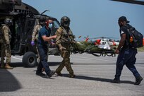 HAITI - Medical volunteers and aircrew with the 1st Battalion, 228th Aviation Regiment, Joint Task Force-Bravo, Soto Cano Air Base, Honduras, unload patients from a UH-60 Black Hawk helicopter during a medical evacuation mission at Port-au-Prince, Haiti, Aug. 24, 2021. At the request of U.S. Southern Command, service members deployed to support relief efforts for the people of Haiti after the nation was hit by an earthquake, Aug. 14. (Photo by Tech. Sgt. Marleah Cabano)