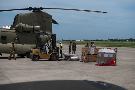 Guantanamo Bay, Cuba - U.S. Agency for International Development and Haitian volunteers load materials onto a U.S. Army CH-47 Chinook helicopter assigned to the 1st Battalion, 228th Aviation Regiment, Joint Task Force-Bravo at Port-au-Prince, Haiti, August 19, 2021. The region was affected by a 7.2 magnitude earthquake and JTF-Bravo deployed assets and personnel to conduct heavy lift transportation of critical and lifesaving supplies into affected areas in Port-au-Prince, Les Cayes, and Annete. (Photo by Tech Sgt Marleah Cabano)