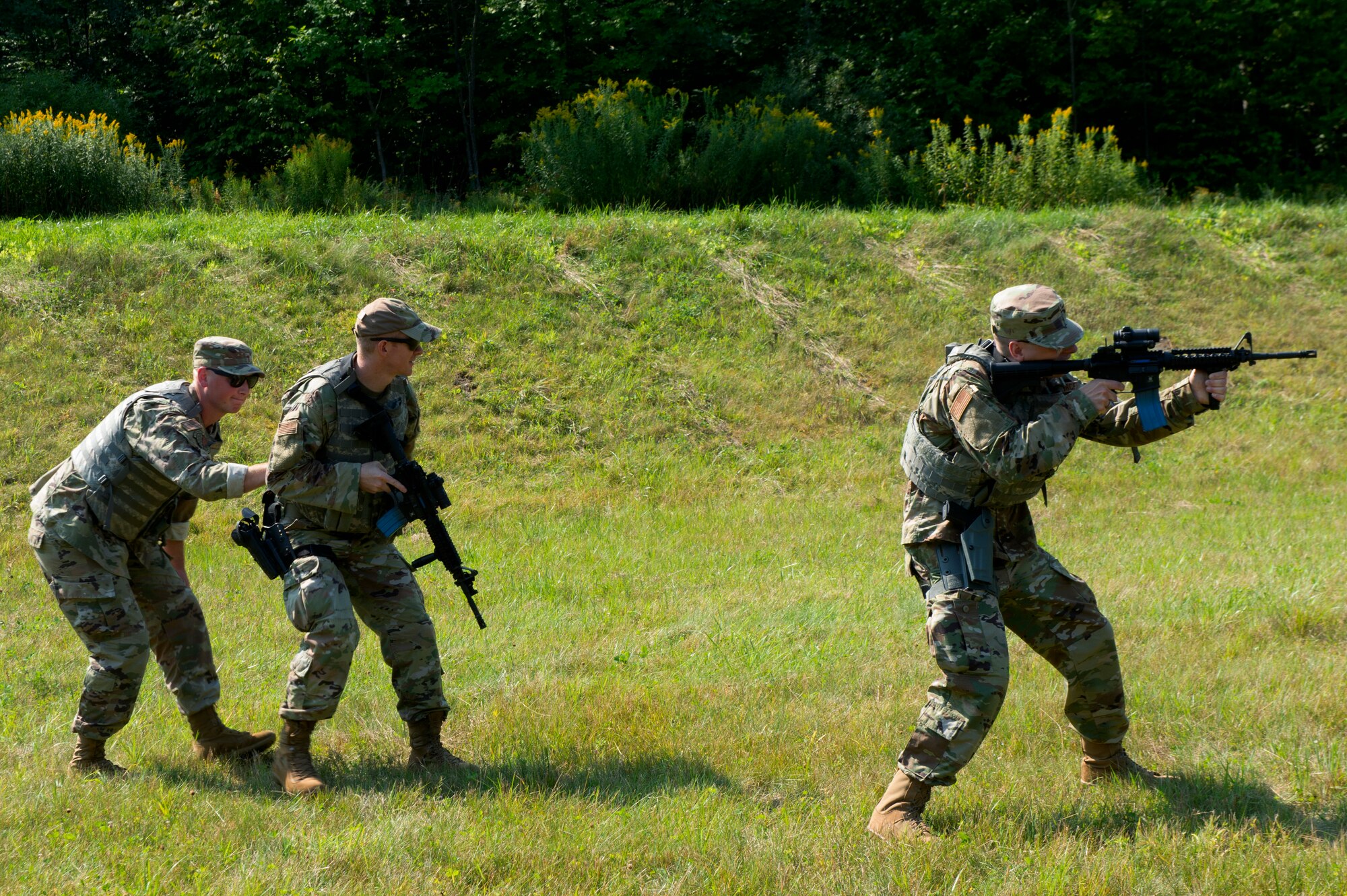 Staff Sgt. Taylor Specht, 158th Fighter Wing chapel readiness NCOIC, and Tech. Sgt. Ryan Brier, 158th FW chapel operations NCOIC, provide simulated cover for Capt. Wilson Treftz, 158th FW chaplain, during the Deployed Security Operations Chaplains Course.