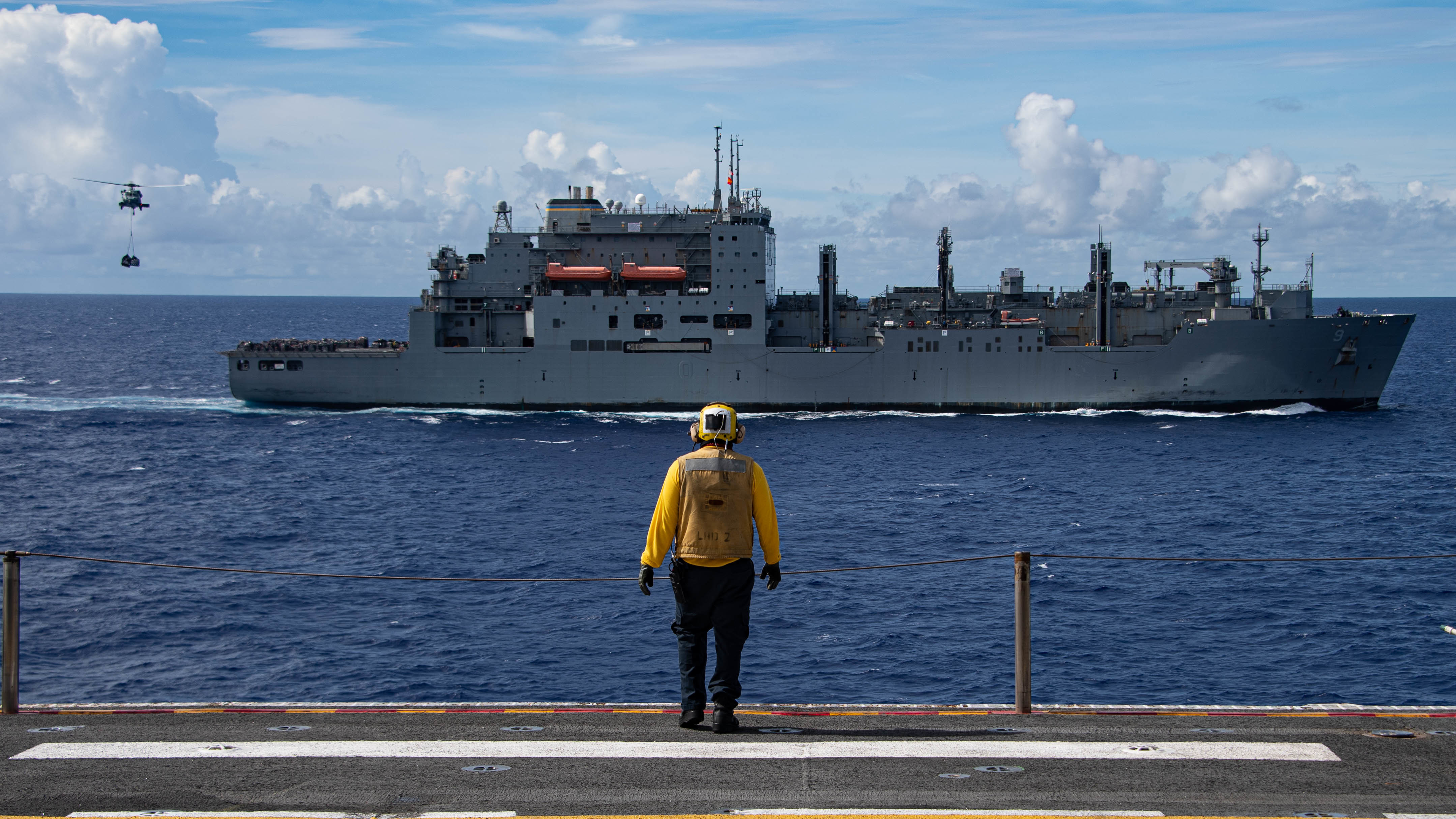 The Dry cargo and ammunition ship USNS Matthew Perry (T-AKE 9) conducts a vertical replenishment (VERTREP) with amphibious assault ship USS Essex (LHD 2).