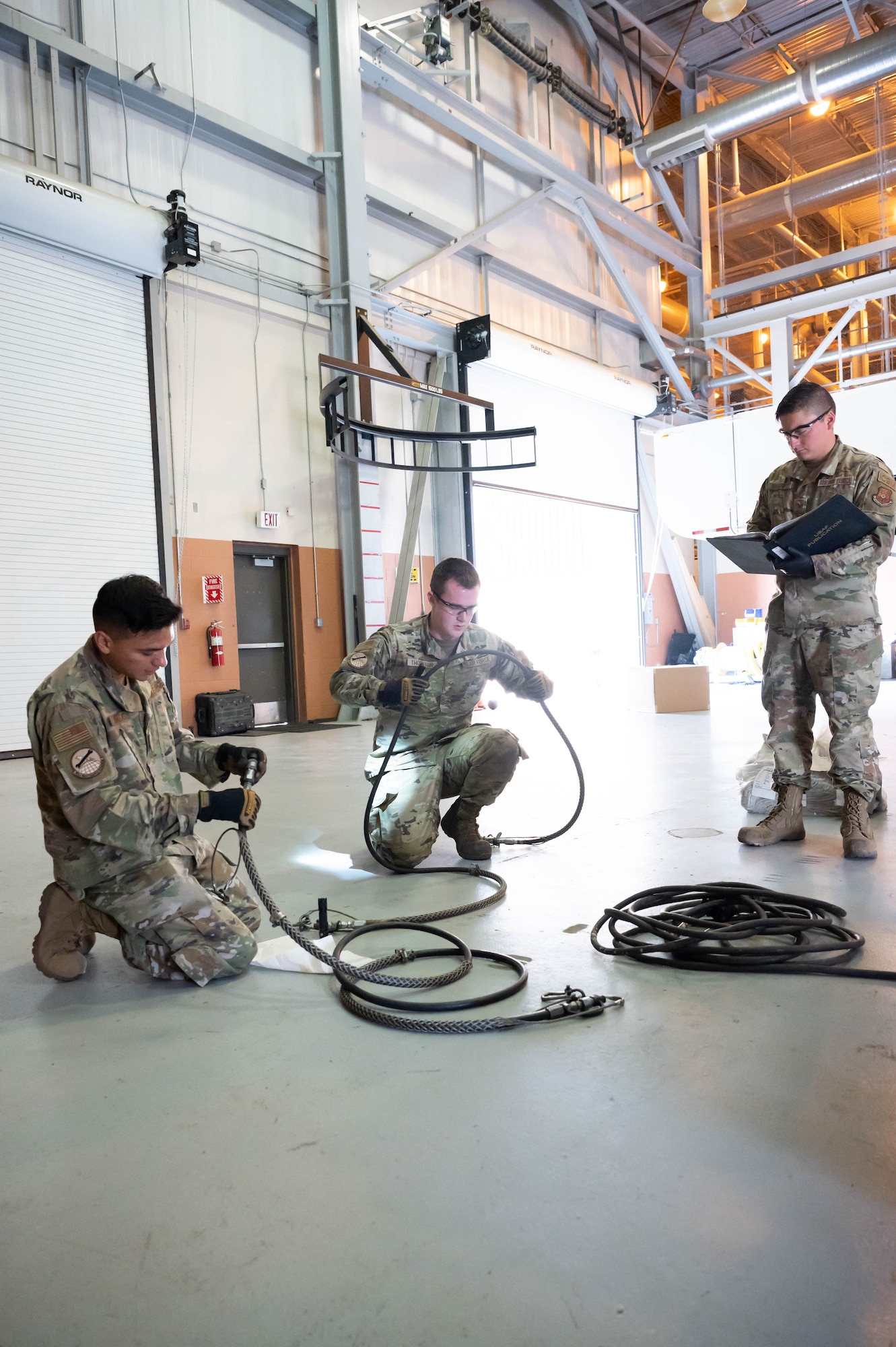 Senior Airman Joseph Vargas, left, Senior Airman Travis Thornton, center, 741st Maintenance Squadron mechanical and pneudraulics technicians, inspect a component of a hydraulic actuator power unit, while Staff Sgt. Steven Navarro, right, 741st MXS MAPS team chief, reads the process checklist July 28, 2021, at Malmstrom Air Force Base, Mont.
