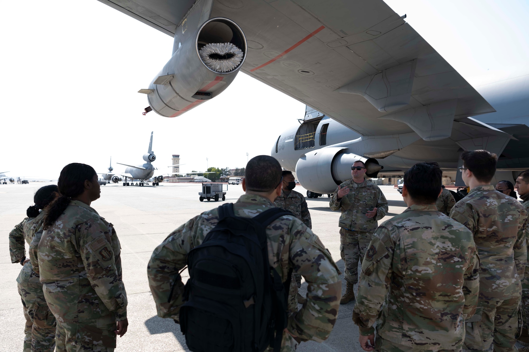 Airmen gather around a wing of an aircraft