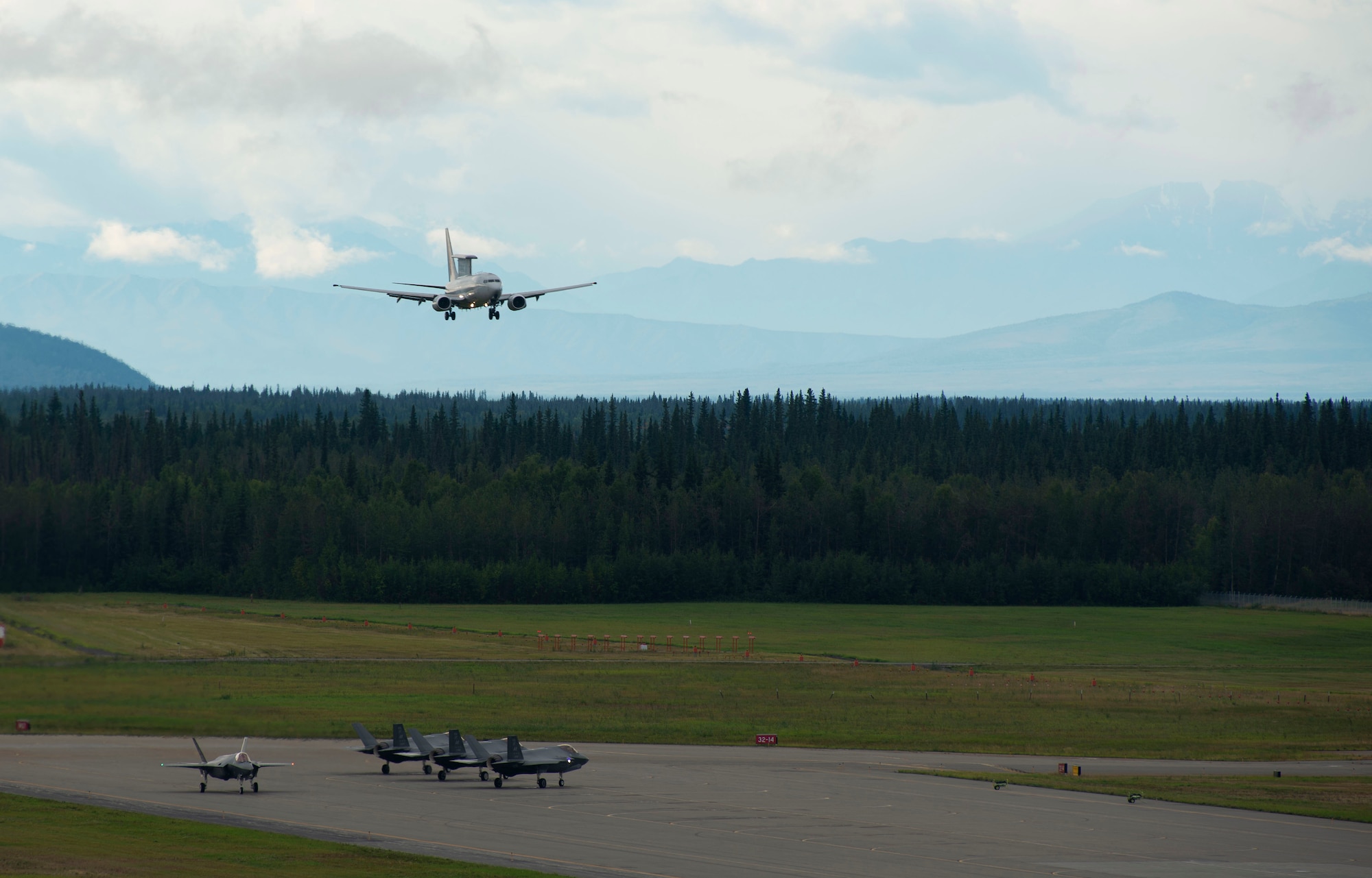 A Royal Australian Air Force E-7A Wedgetail prepares to land while U.S. Air Force F-35A Lighting IIs prepare to take off on Eielson Air Force Base, Alaska, Aug. 11, 2021. RAAF personnel last visited Alaska in 2019 to participate in RF-A 19-3, before the 354th Fighter Wing accepted its first F-35As. This time the Australians brought their own F-35As as well as EA-18G Growlers and an E-7A Wedgetail to exercise air-to-air combat as well as cyber and intelligence capabilities.(U.S. Air Force photo by Senior Airman Beaux Hebert)