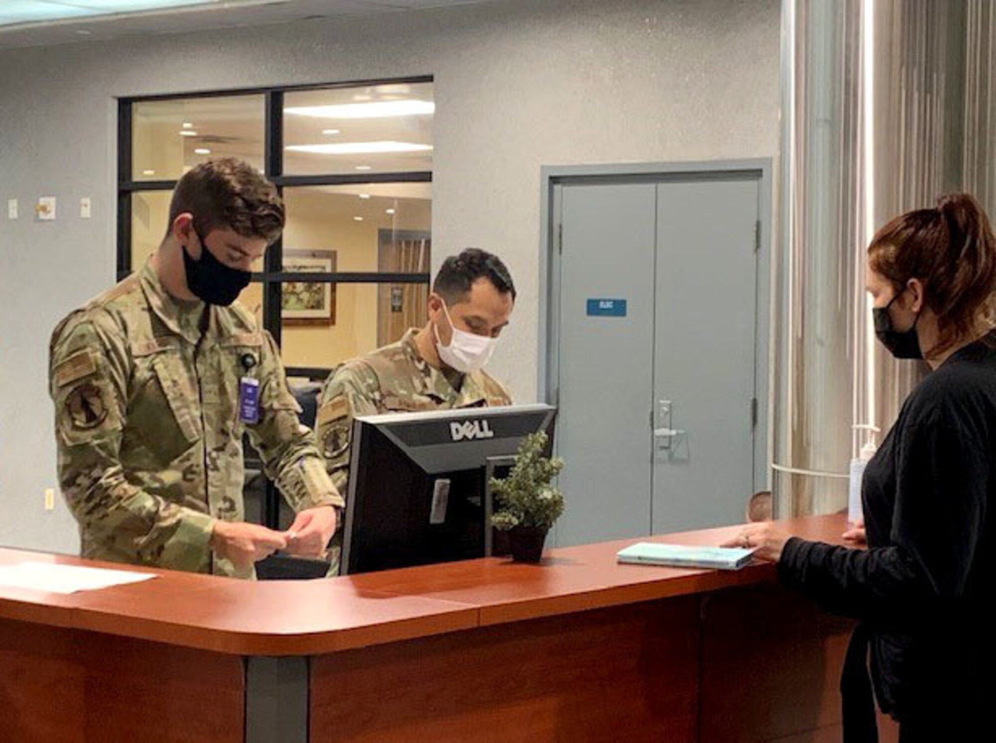 Airmen help as passenger at the counter.
