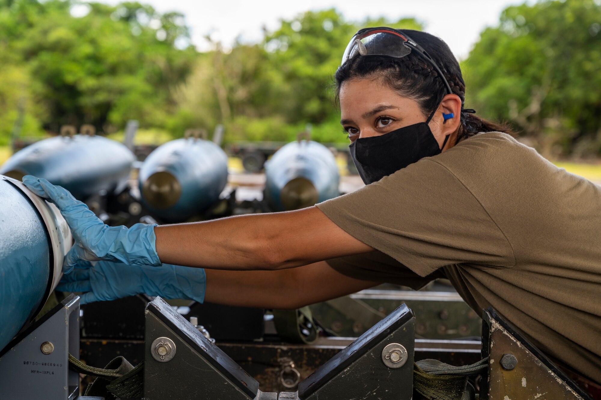 U.S. Air Force Staff Sgt. Amanda Solis, a conventional maintenance inspector, assigned to the 2nd Munitions Squadron, Barksdale Air Force Base, Louisiana, lays a stencil to spray paint identifying marks on the side of a BDU-50 training bomb for Bomber Task Force missions at Andersen Air Force Base, Guam, Aug. 27, 2021. This deployment allows aircrew and support personnel to conduct theater integration and to improve bomber interoperability with allies and partners. (U.S. Air Force photo by Staff Sgt. Alysia T. Blake)