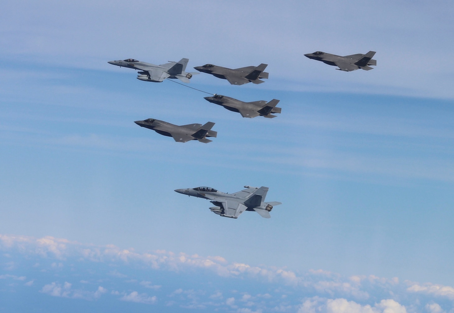 PHILIPPINE SEA (Aug. 26, 2021) Two F-35B Lightning II from Marine Fighter Attack Squadron (VMFA) 211, embarked on the Royal Navy aircraft carrier HMS Queen Elizabeth (R08); two F-35C Lightning II assigned to Strike Fight Squadron (VFA) 147; an EA-18G Growler, assigned to U.S. Navy Electronic Attack Squadron (VAQ) 136; and an F/A-18E Super Hornet, assigned to Strike Fighter Squadron (VFA) 192, embarked on aircraft carrier USS Carl Vinson (CVN 70), conduct mid-air refueling in support of joint interoperability flights between Carl Vinson Carrier Strike Group (VINCSG) and U.K. Carrier Strike Group (CSG-21), Aug. 26, 2021. Carl Vinson Carrier Strike Group is on deployment in the U.S. 7th Fleet area of operations to enhance interoperability with allies and partners, and to serve as a ready-response force in support of a free and open Indo-Pacific region. (U.S. Navy photo by Lt. Cmdr. Bart Crowder)