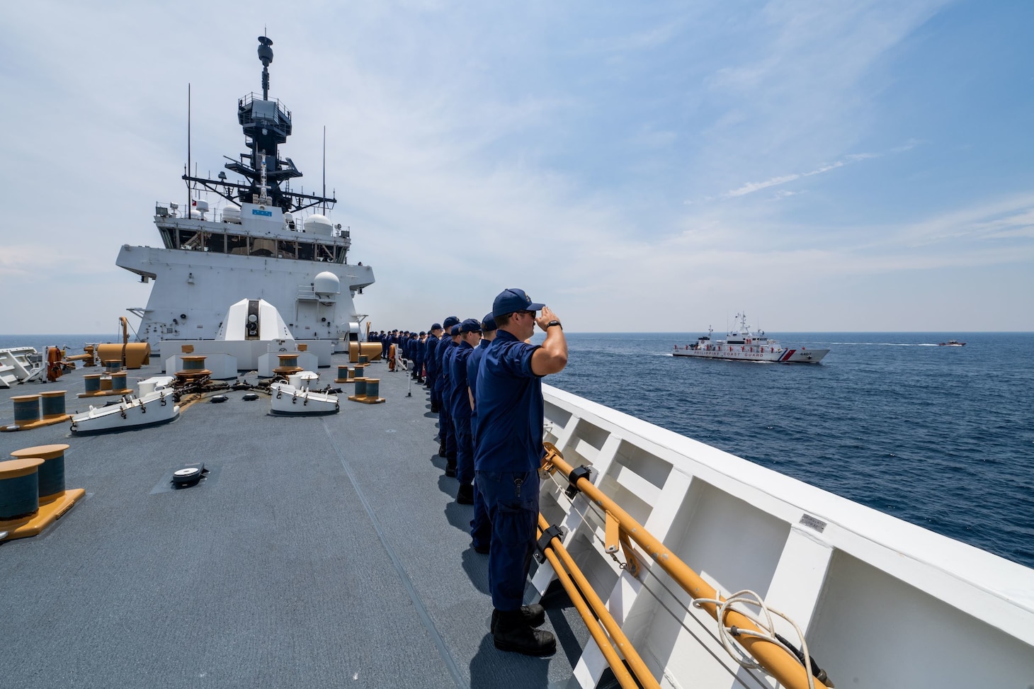 Crewmembers of the U.S. Coast Guard Cutter Munro salute a Philippine Coast Guard vessel transiting alongside the Munro in the West Philippine Sea, Aug. 31, 2021. Coast Guard members aboard the Munro and the Philippine Coast Guard participated in bilateral operations and exercises that included small boat operations and multi-vessel maneuvering. (U.S. Coast Guard photo by Petty Officer 3rd Class Aidan Cooney)