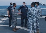 U.S. Coast Guard Capt. Blake Novak (center), commanding officer of U.S. Coast Guard Cutter Munro, speaks with members of the Philippine Coast Guard during a maritime engagement Aug. 31, 2021, in the West Philippine Sea. Operating under the tactical control of U.S. 7th Fleet, the cutter and crew are engaging in professional exchanges and capacity-building exercises with partner nations and are patrolling and conducting operations as directed. (U.S. Coast Guard photo by Marine Corps Sgt. Kevin G. Rivas)