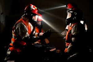Airmen from the 155th Chemical Biological Radiological Nuclear Enhanced Response Force Package search and extraction team discuss patients found in a building collapse exercise, Aug. 17, 2021, in Lincoln, Neb.