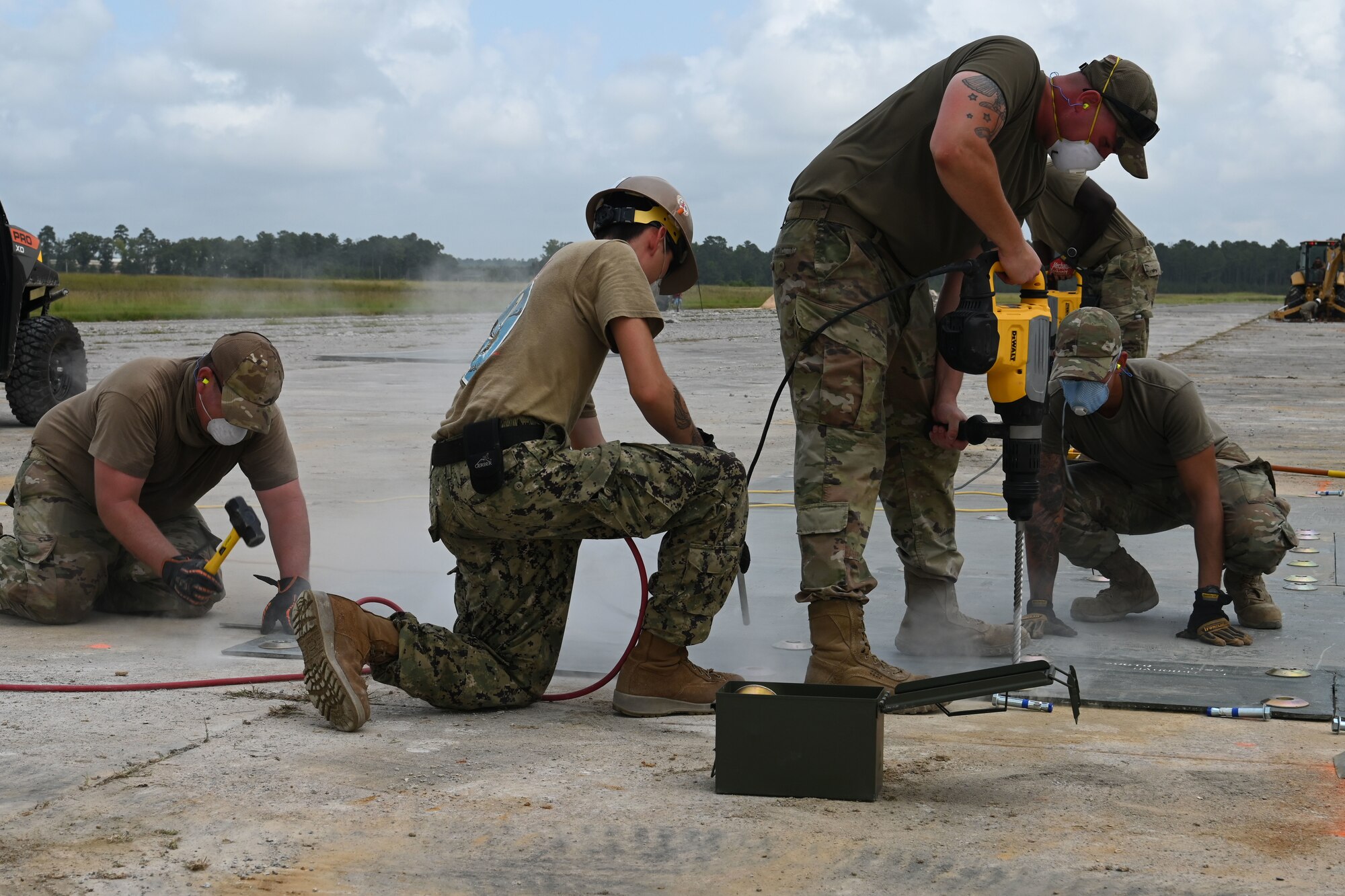 U.S. Air Force civil engineers from the pavements and construction equipment career field, known as the Dirt Boys from eight separate units, team up with U.S. Navy Seabees from the Naval Mobile Construction Battalion 133, Gulfport, Mississippi for an Expedient and Expeditionary Airfield Damage Repair (E-ADR) demonstration at McEntire Joint National Guard Base, South Carolina, Aug. 27, 2021. The purpose of the training is to provide just enough, just in time repair capability with minimal cost and materials in a wartime situation.  (U.S. Air National Guard photo by Senior Master Sgt. Edward Snyder, 169th Fighter Wing Public Affairs)