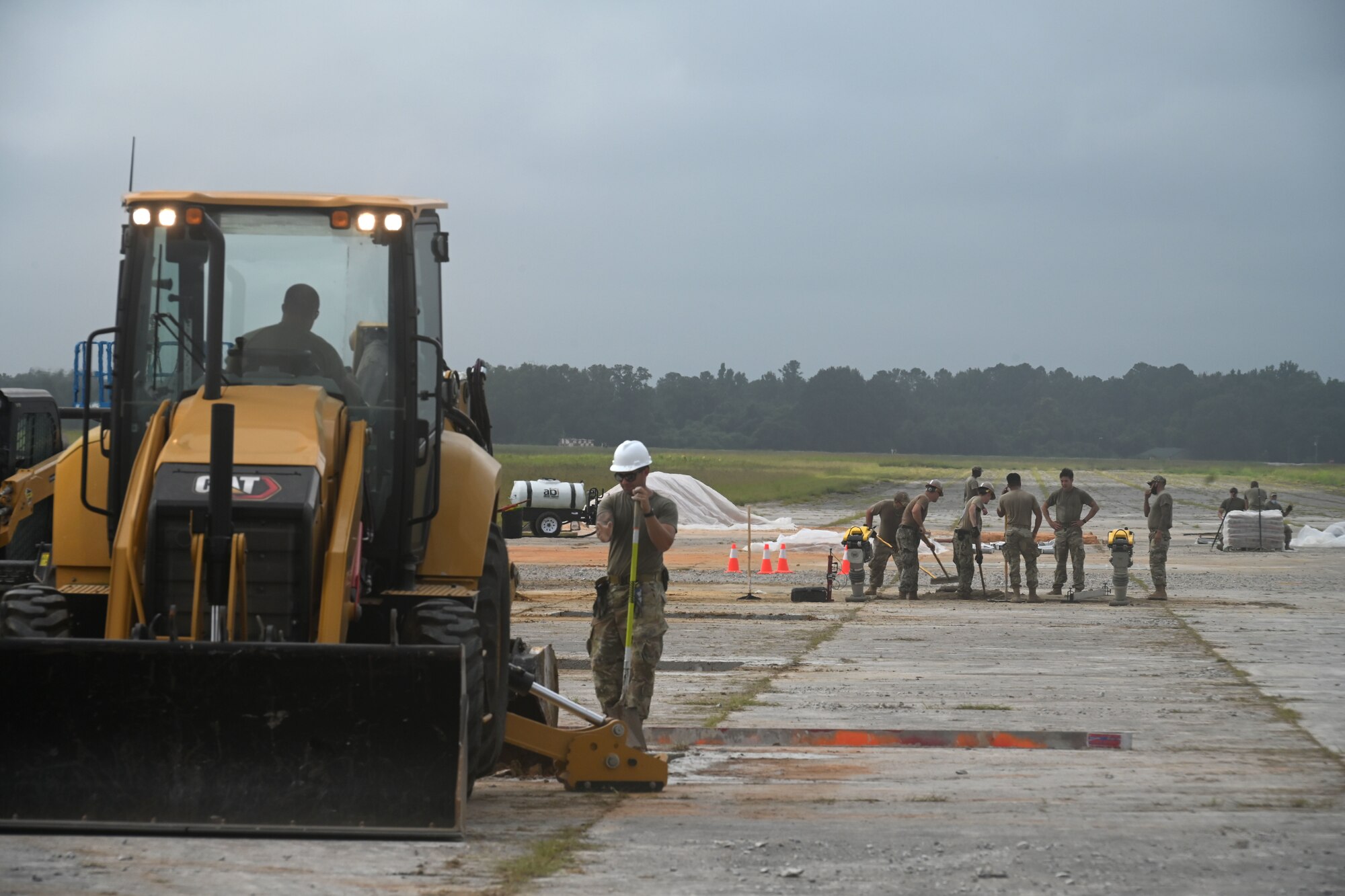 U.S. Air Force civil engineers from the pavements and construction equipment career field, known as the Dirt Boys from eight separate units, team up with U.S. Navy Seabees from the Naval Mobile Construction Battalion 133, Gulfport, Mississippi for an Expedient and Expeditionary Airfield Damage Repair (E-ADR) demonstration at McEntire Joint National Guard Base, South Carolina, Aug. 27, 2021. The purpose of the training is to provide just enough, just in time repair capability with minimal cost and materials in a wartime situation.  (U.S. Air National Guard photo by Senior Master Sgt. Edward Snyder, 169th Fighter Wing Public Affairs)