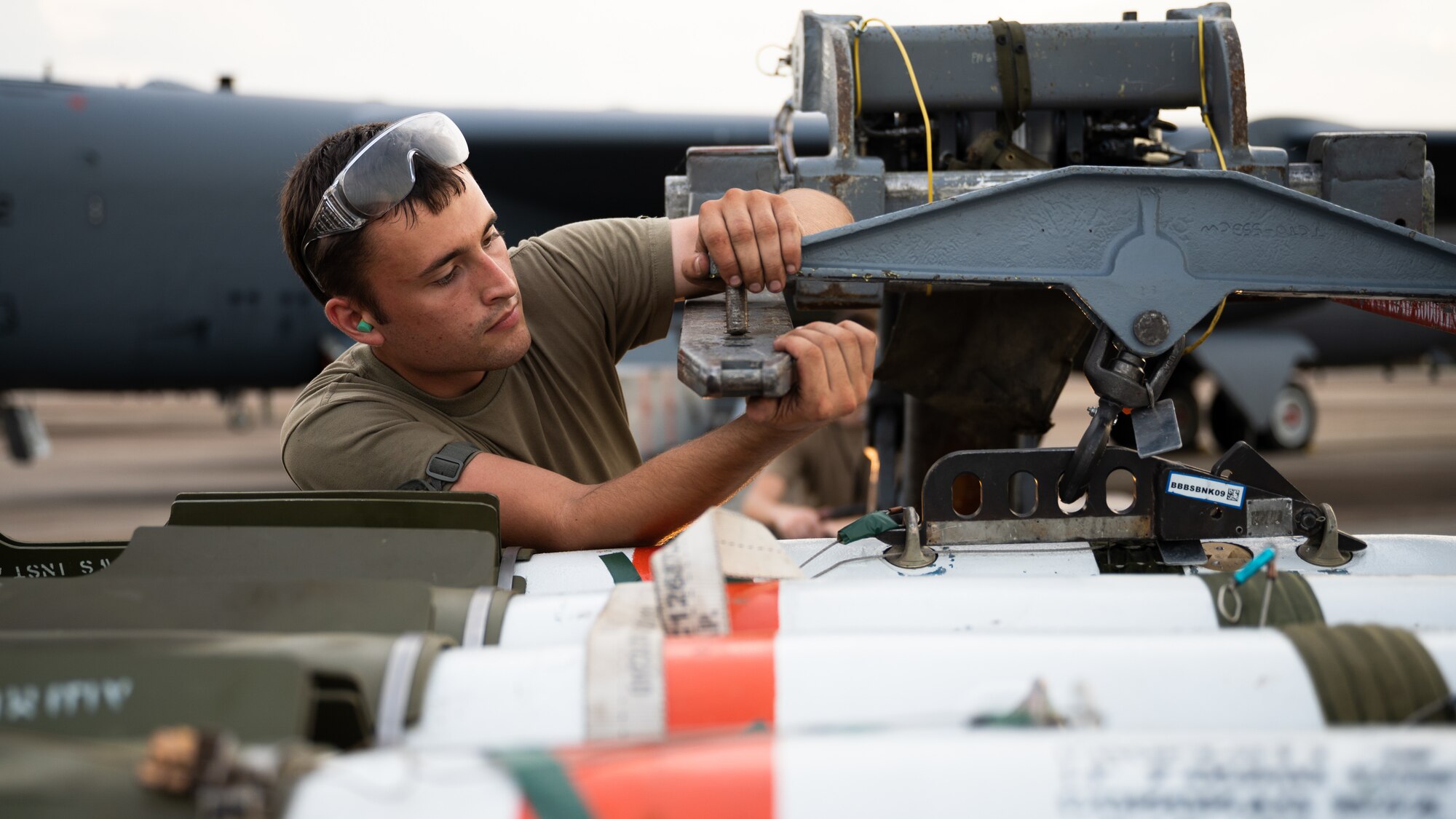 Senior Airman William Oskay, 2nd Aircraft Maintenance Squadron weapons load crew member, prepares to transfer a MK-62 Quickstrike naval mine in support of a Bomber Task Force deployment at Barksdale Air Force Base, Louisiana, Aug. 25, 2021. The MK-62 mine is a shallow water aircraft laid mine used primarily against surface and subsurface water craft. (U.S. Air Force photo by Senior Airman Jacob B. Wrightsman)