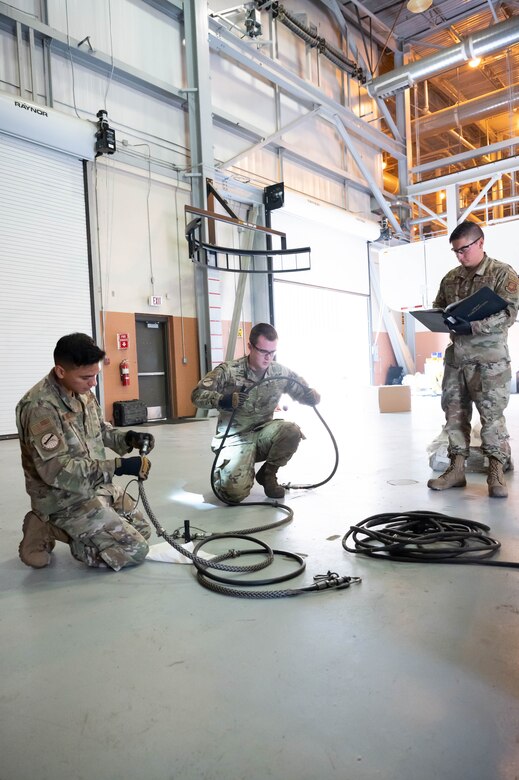 Senior Airman Joseph Vargas, left, Senior Airman Travis Thornton, center, 741st Maintenance Squadron mechanical and pneudraulics technicians, inspect a component of a hydraulic actuator power unit, while Staff Sgt. Steven Navarro, right, 741st MXS MAPS team chief, reads the process checklist July 28, 2021, at Malmstrom Air Force Base, Mont.