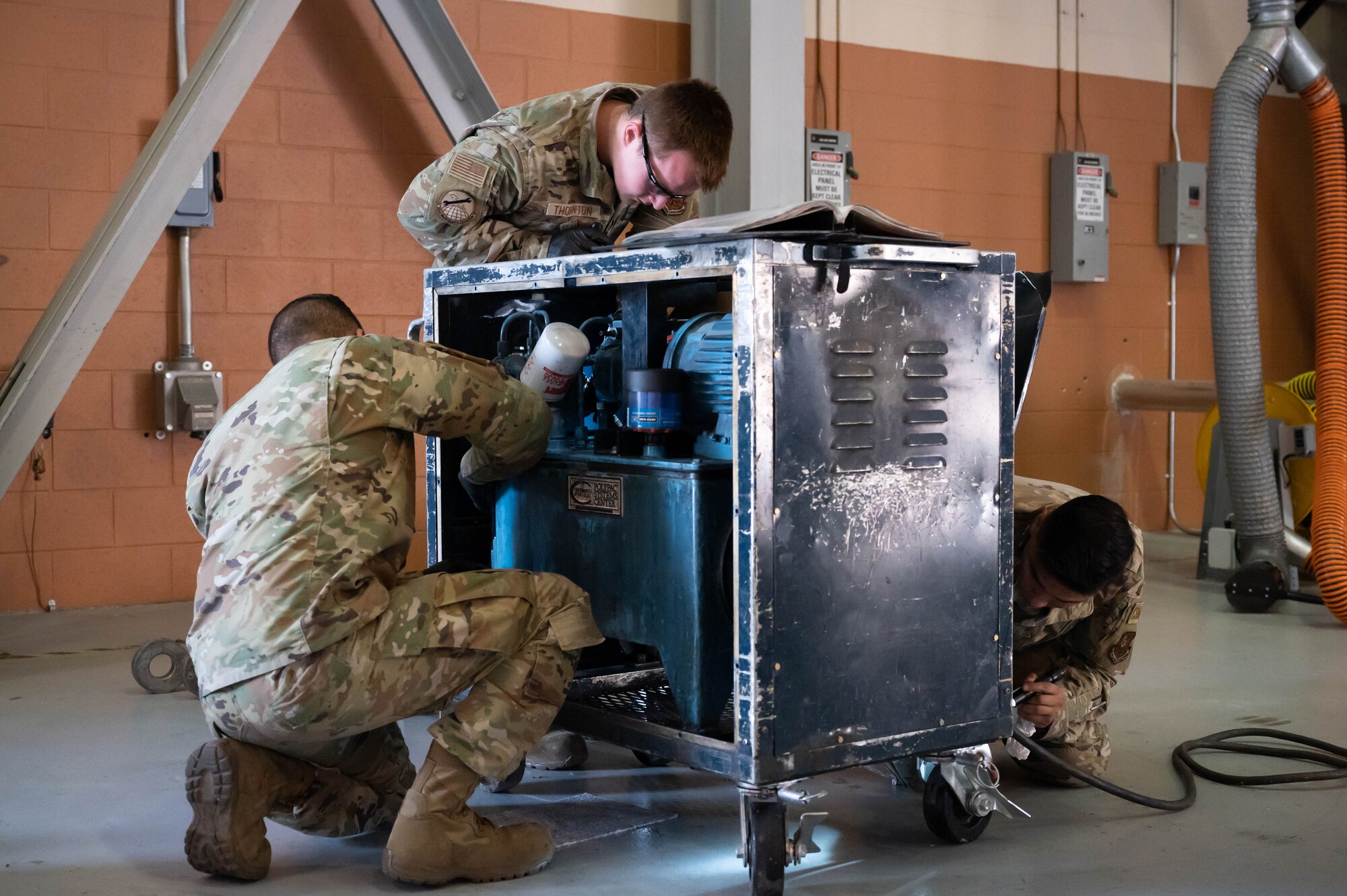Staff Sgt. Steven Navarro, left, 741st Maintenance Squadron mechanical and pneudraulics team chief; Senior Airman Travis Thornton, center, and Senior Airman Joseph Vargas, right, 741st MXS MAPS technicians, inspect a component of a hydraulic actuator power unit July 28, 2021, at Malmstrom Air Force Base, Mont.