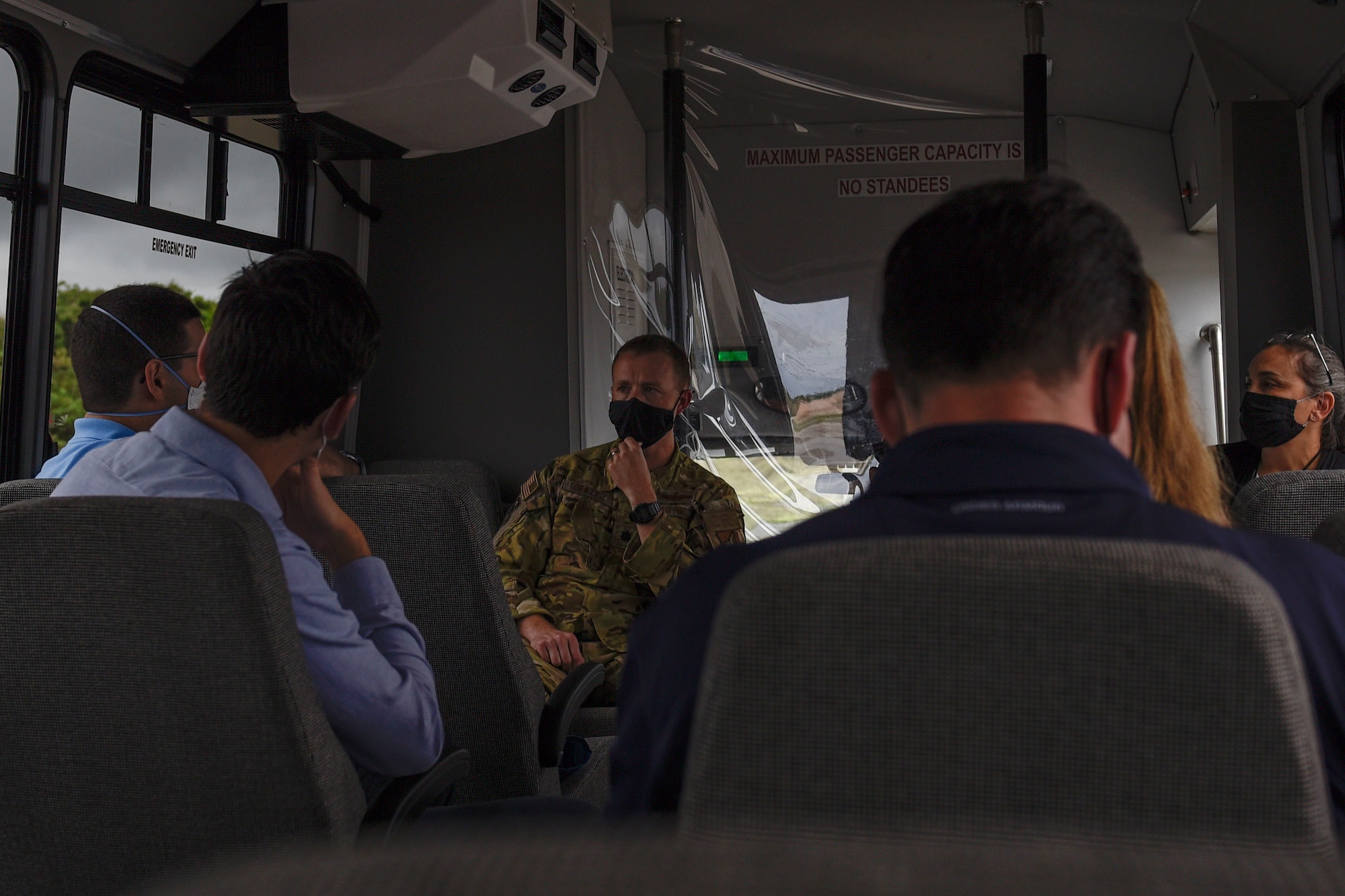 A group of people sitting on a bus and talking.