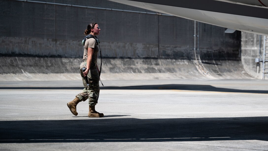 U.S. Air Force Staff Sgt. Colleen Clay, 961st Aircraft Maintenance Unit crew chief, walks the perimeter of an E-3 Sentry at Kadena Air Base, Japan, Aug. 30, 2021. Crew chiefs are responsible for the overall maintenance of their assigned aircraft. (U.S. Air Force photo by Airman 1st Class Stephen Pulter)