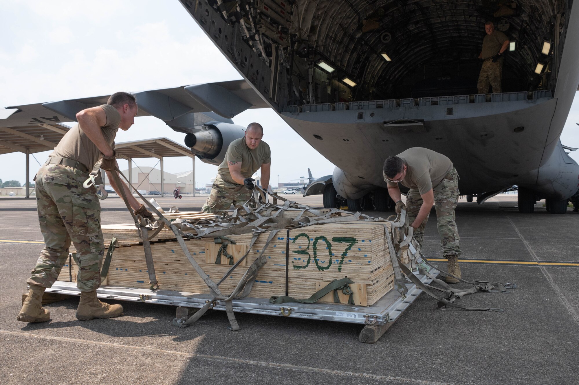 Three men grab at the straps on a ramp.