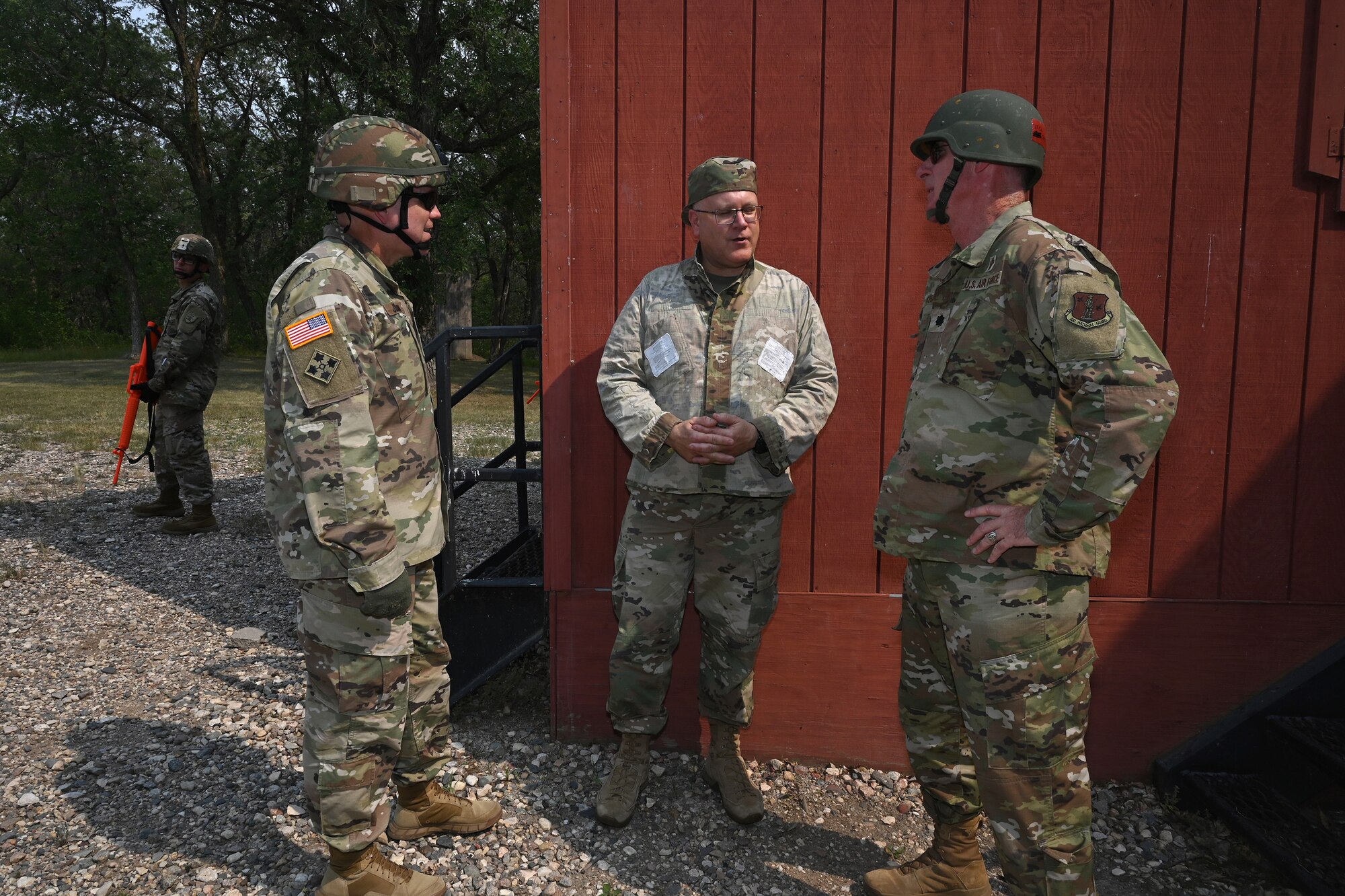 Three North Dakota National Guard chaplains in military uniform simulate discussions as if meeting in a foreign land during training at Camp Grafton Training Center, N.D., Aug. 3, 2021.