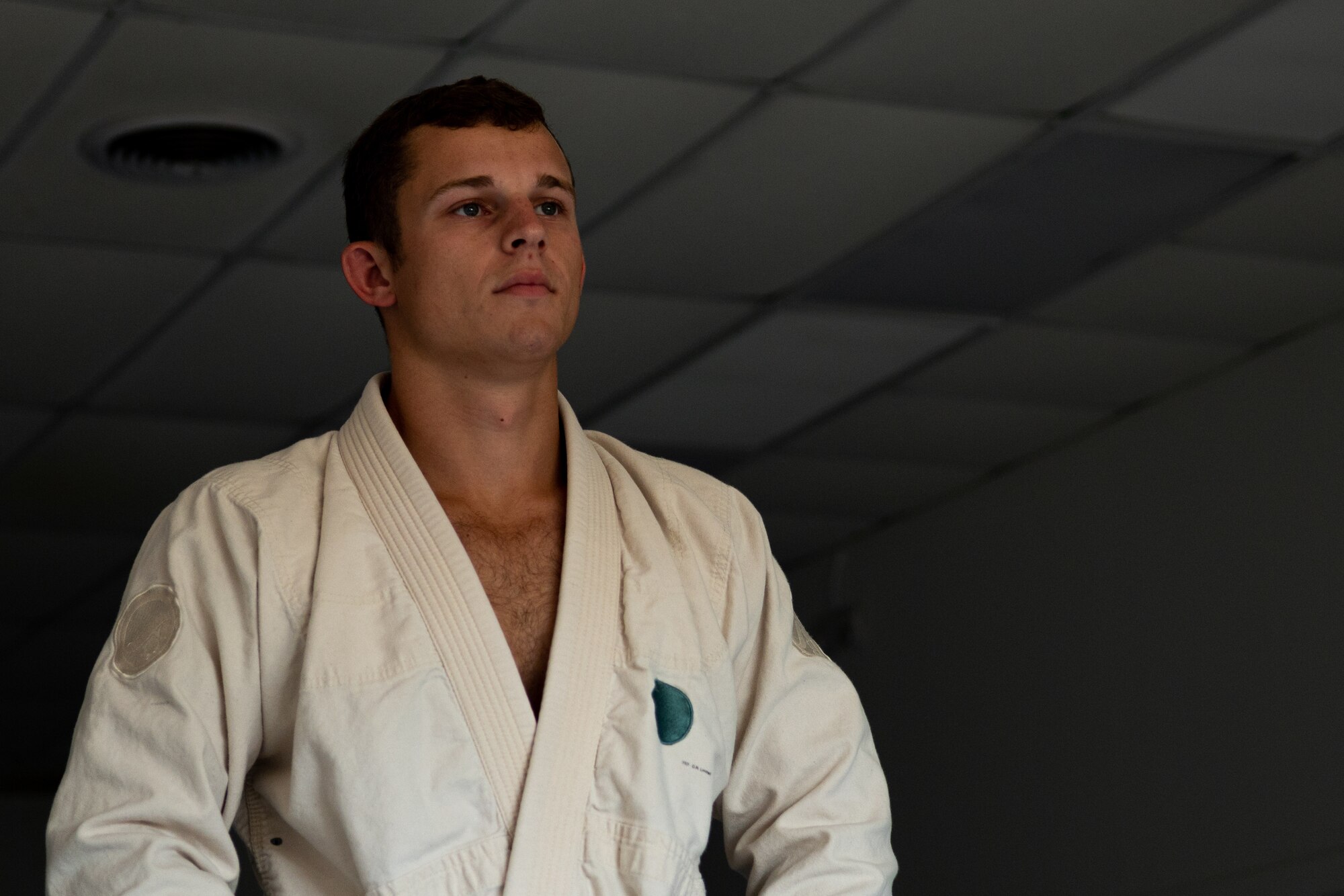 Senior Airman Brian Price, a 4th Civil Engineer Squadron explosive ordnance disposal technician poses for a photo in Goldsboro, North Carolina, Aug. 13, 2021. Price is wearing a gi which is the standard clothing worn while training in Brazilian Jiu Jitsu. (U.S. Air Force photo by Senior Airman David Lynn)
