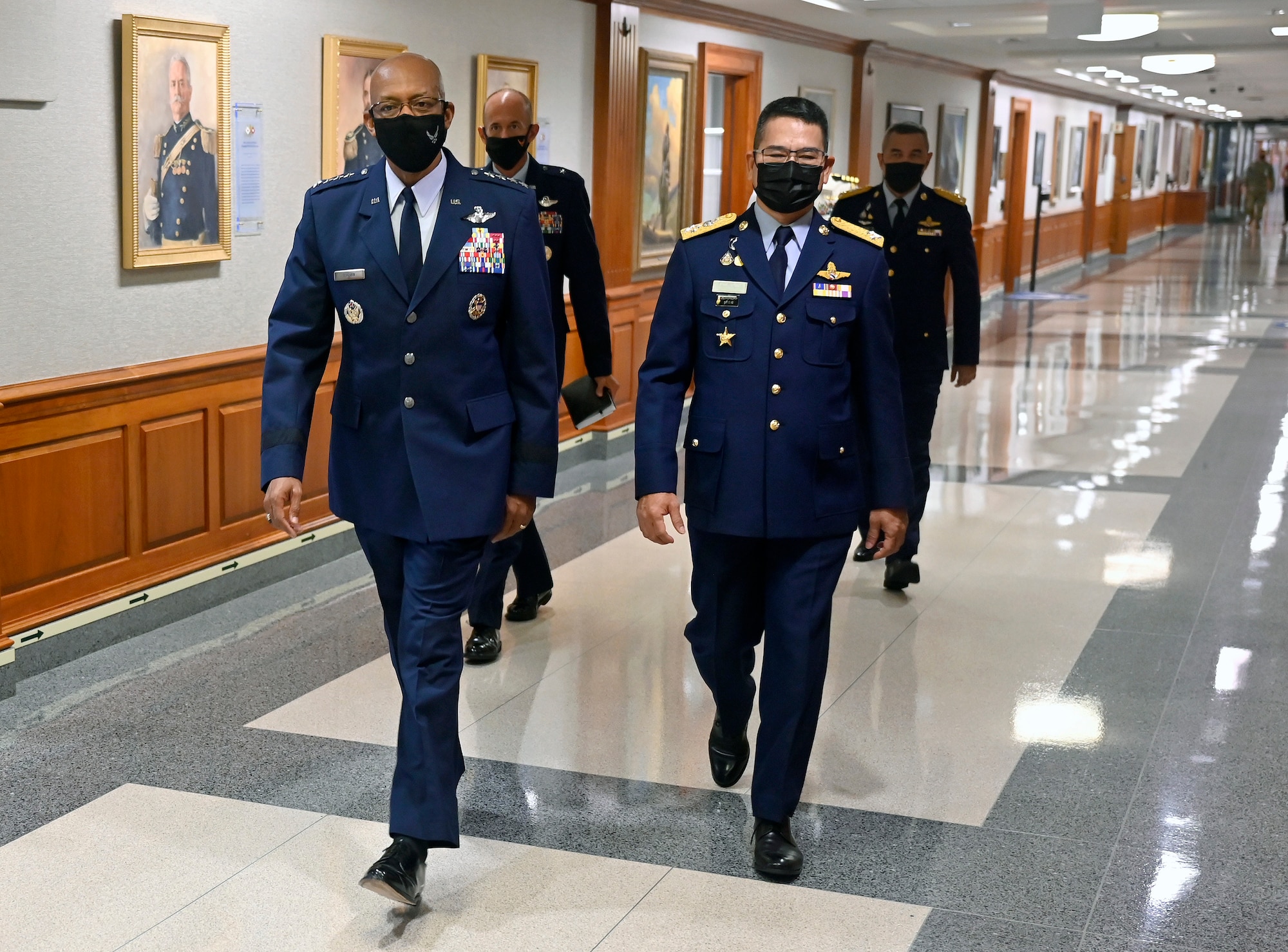 Gen. CQ Brown, Jr., left, walks with Air Chief Marshal Chanon Mungthanya