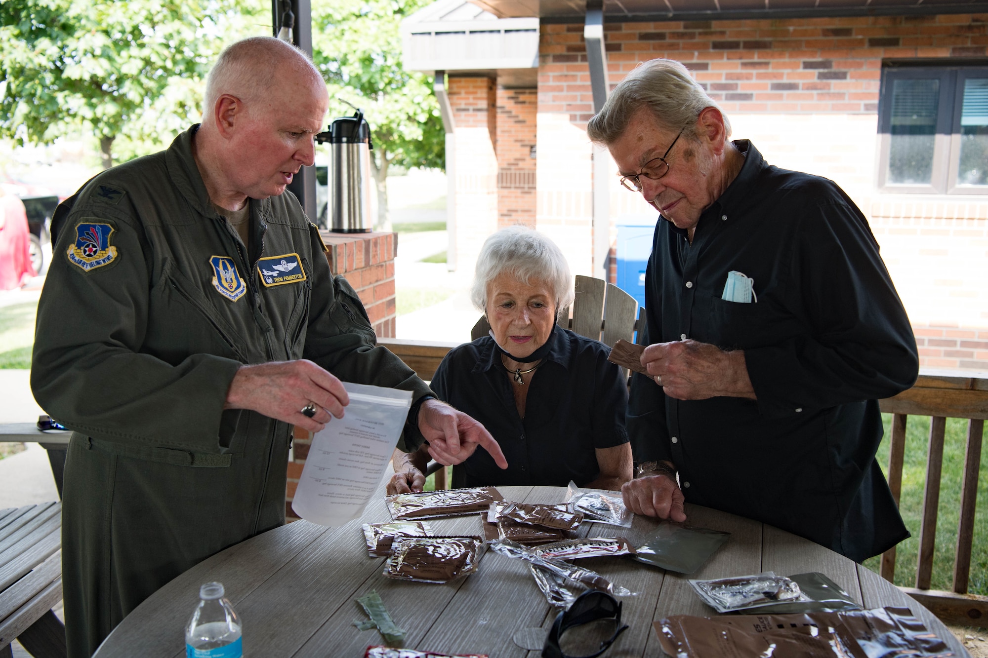 Col. Thom Pemberton, 434th Air Refueling Wing commander, goes over the finer points of cooking an MRE to Phil and Joan Lake during a Grissom Community Council outing Aug. 20, 2021. The GCC members visited the base, watched as unit members responded to a wartime scenario before dining at Chocks. (U.S. Air Force photo/Staff Sgt. Jeremy Blocker)