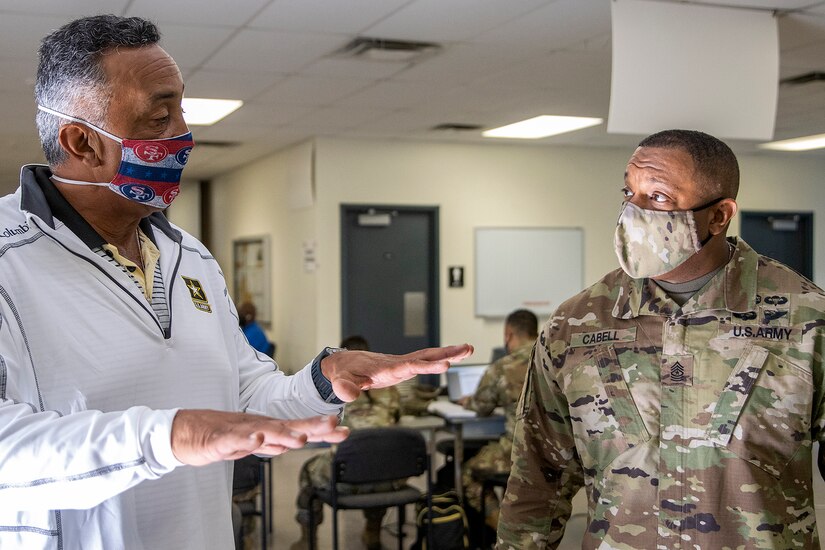 Vernard Bendy, U.S. Army Financial Management Command Fort Bliss Army Military Pay Office director, explains to Sgt. Maj. Darnell Cabell, senior enlisted leader and principle advisor to the military deputy to the Assistant Secretary of the Army for Financial Management and Comptroller, that Diamond Saber exercise participants are using live pay records to train on military pay operations at Fort McCoy, Wisconsin, Aug. 17, 2021. Diamond Saber is a U.S. Army Reserve-led exercise that incorporates all Army components and joint services, and it prepares finance and comptroller Soldiers on warfighting functions such as funding the force, payment support, disbursing operations, accounting, fiscal stewardship, auditability and data analytics. (U.S. Army photo by Mark R. W. Orders-Woempner)