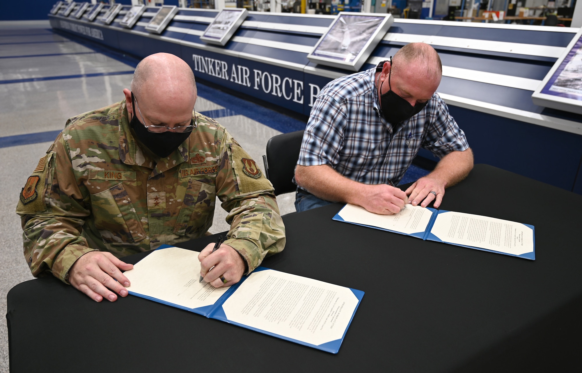 Two men at a table signing documents