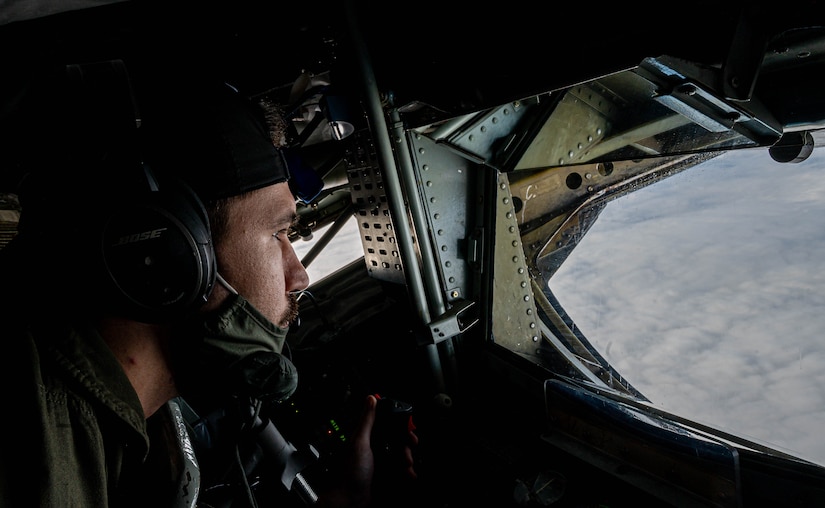 An Airman prepares to refuel a jet mid-air.