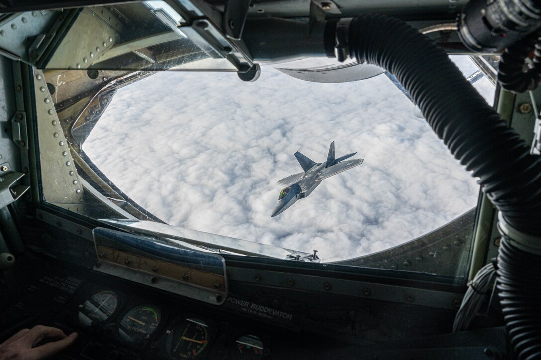 A jet departs after a mid-air refuel.