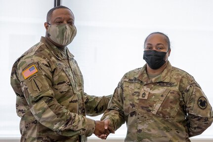 Sgt. Maj. Darnell Cabell, senior enlisted leader and principle advisor to the military deputy to the Assistant Secretary of the Army for Financial Management and Comptroller, presents his challenge coin for excellence to Master Sgt. Teresa Price, U.S. Army Reserve Command finance operations advisor, during Diamond Saber at Fort McCoy, Wisconsin, Aug. 17, 2021. Diamond Saber is a U.S. Army Reserve-led exercise that incorporates all Army components and joint services, and it prepares finance and comptroller Soldiers on warfighting functions such as funding the force, payment support, disbursing operations, accounting, fiscal stewardship, auditability and data analytics. (U.S. Army photo by Mark R. W. Orders-Woempner)