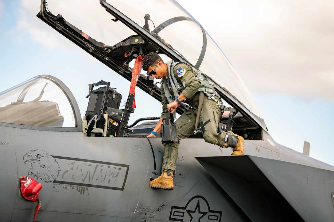 An airman steps out of the cockpit of an aircraft.