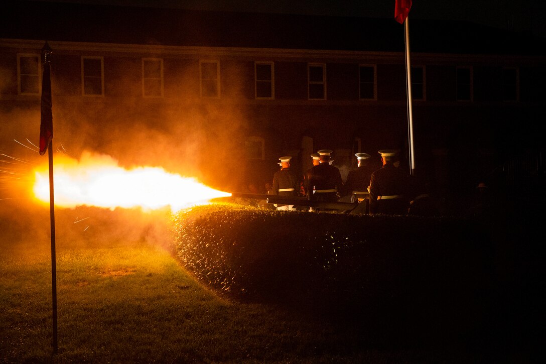 Marines fire weapons during a night parade.