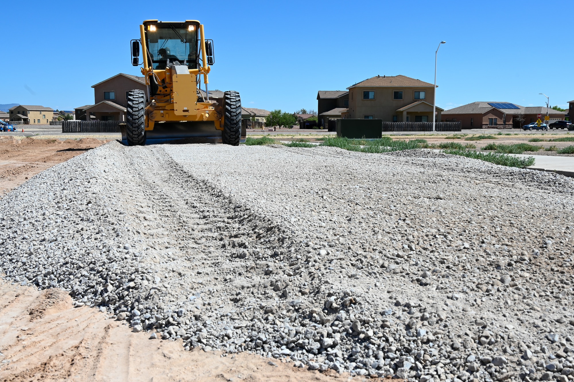 Tech. Sgt. Alonzo Marquez, 49th Civil Engineer Squadron noncommissioned officer in charge of pavements and construction equipment, smooths gravel at a future housing site for Task Force-Holloman personnel Aug. 26, 2021, on Holloman Air Force Base, New Mexico. The Department of Defense, through U.S. Northern Command, and in support of the Department of Homeland Security, is providing transportation, temporary housing, medical screening, and general support for up to 50,000 Afghan evacuees at suitable facilities, in permanent or temporary structures, as quickly as possible. This initiative provides Afghan personnel essential support at secure locations outside Afghanistan. (U.S. Air Force photo by Tech. Sgt. BreeAnn Sachs)