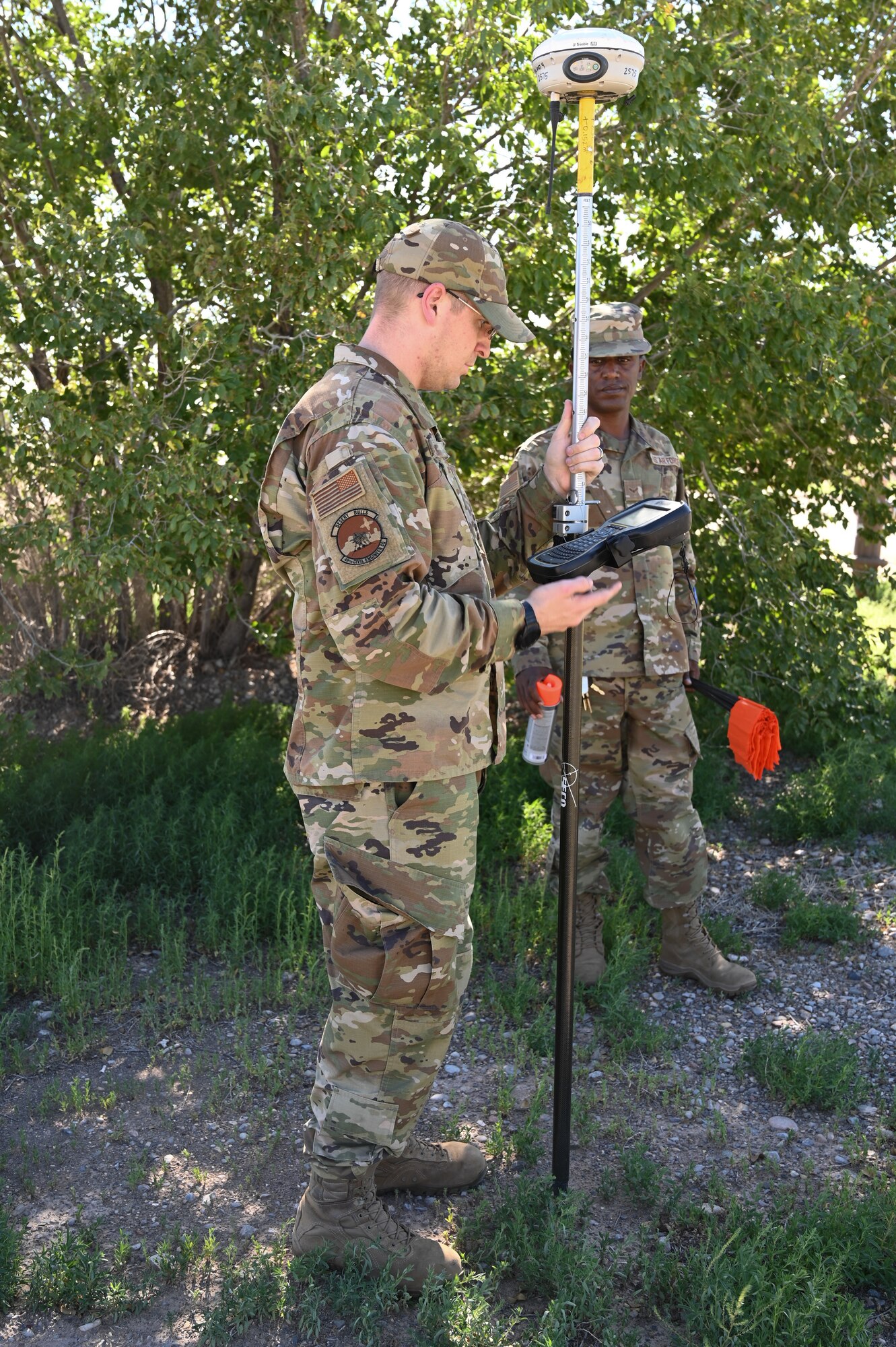 (From left to right) Tech. Sgt. Izaak Cary, 49th Civil Engineer Squadron noncommissioned officer in charge of drafting and surveying, and Airman 1st Class Wozzen Zewdie, 49th CES engineering specialist, map trees at a future housing site for Task Force-Holloman personnel site Aug. 26, 2021 on Holloman Air Force Base, New Mexico. The Department of Defense, through U.S. Northern Command, and in support of the Department of Homeland Security, is providing transportation, temporary housing, medical screening, and general support for up to 50,000 Afghan evacuees at suitable facilities, in permanent or temporary structures, as quickly as possible. This initiative provides Afghan personnel essential support at secure locations outside Afghanistan. (U.S. Air Force photo by Tech. Sgt. BreeAnn Sachs)