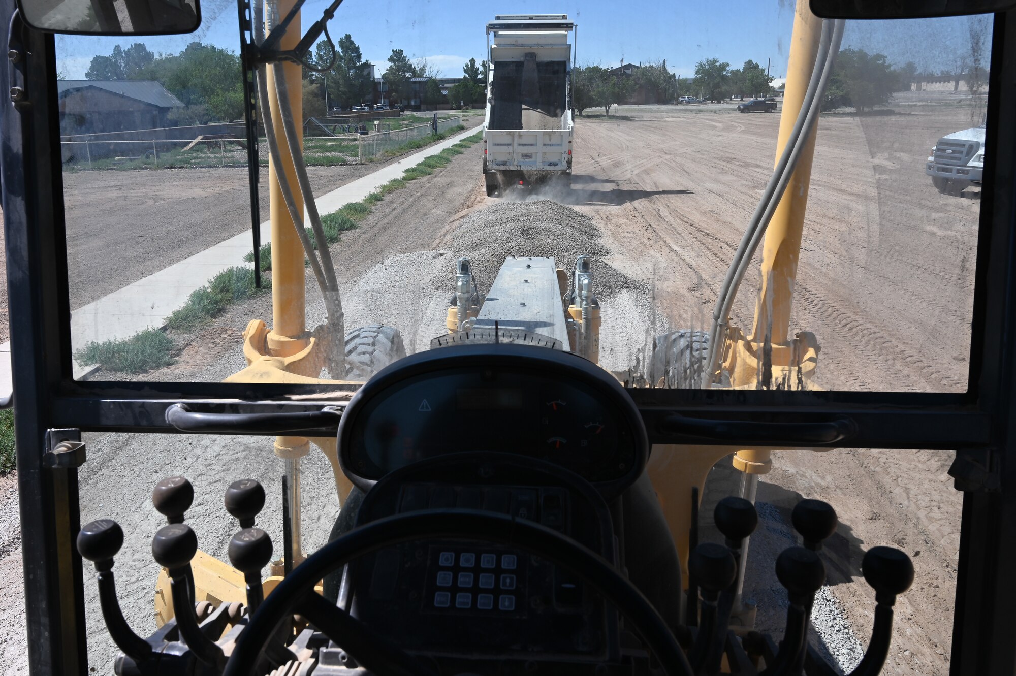 A 49th Civil Engineer Squadron Airman drops gravel at a future housing site for Task Force-Holloman personnel Aug. 26, 2021, on Holloman Air Force Base, New Mexico. TThe Department of Defense, through U.S. Northern Command, and in support of the Department of Homeland Security, is providing transportation, temporary housing, medical screening, and general support for up to 50,000 Afghan evacuees at suitable facilities, in permanent or temporary structures, as quickly as possible. This initiative provides Afghan personnel essential support at secure locations outside Afghanistan. (U.S. Air Force photo by Tech. Sgt. BreeAnn Sachs)