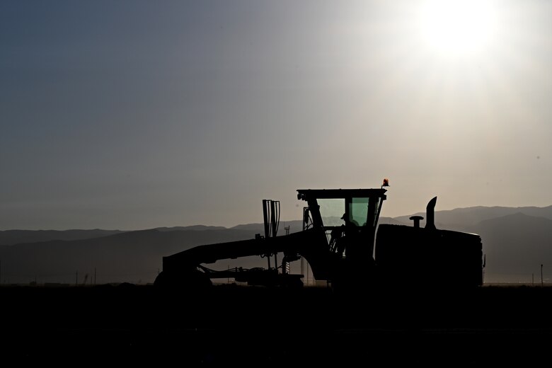 An Airman assigned to the 49th Civil Engineer Squadron spreads gravel with a grader at a future Afghan personnel housing facility construction site in support of Operation Allies Welcome, Aug. 28, 2021, on Holloman Air Force Base, New Mexico. The Department of Defense, through U.S. Northern Command, and in support of the Department of Homeland Security, is providing transportation, temporary housing, medical screening, and general support for up to 50,000 Afghan evacuees at suitable facilities, in permanent or temporary structures, as quickly as possible. This initiative provides Afghan personnel essential support at secure locations outside Afghanistan. (U.S. Air Force photo by Staff Sgt. Christopher S. Sparks)