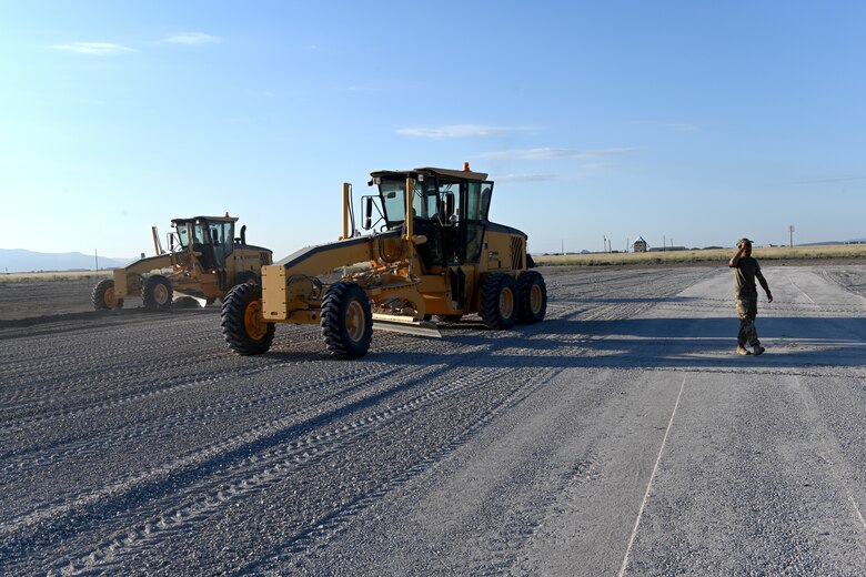 Airmen assigned to the 49th Civil Engineer Squadron spreads gravel with a grader at a future Afghan personnel housing facility construction site in support of Operation Allies Welcome, Aug. 28, 2021, on Holloman Air Force Base, New Mexico. The Department of Defense, through U.S. Northern Command, and in support of the Department of Homeland Security, is providing transportation, temporary housing, medical screening, and general support for up to 50,000 Afghan evacuees at suitable facilities, in permanent or temporary structures, as quickly as possible. This initiative provides Afghan personnel essential support at secure locations outside Afghanistan. (U.S. Air Force photo by Staff Sgt. Christopher S. Sparks)