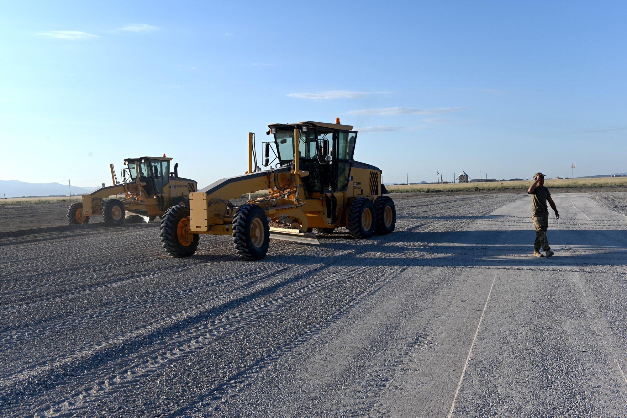 Airmen assigned to the 49th Civil Engineer Squadron spreads gravel with a grader at a future Afghan personnel housing facility construction site in support of Operation Allies Welcome, Aug. 28, 2021, on Holloman Air Force Base, New Mexico. The Department of Defense, through U.S. Northern Command, and in support of the Department of Homeland Security, is providing transportation, temporary housing, medical screening, and general support for up to 50,000 Afghan evacuees at suitable facilities, in permanent or temporary structures, as quickly as possible. This initiative provides Afghan personnel essential support at secure locations outside Afghanistan. (U.S. Air Force photo by Staff Sgt. Christopher S. Sparks)
