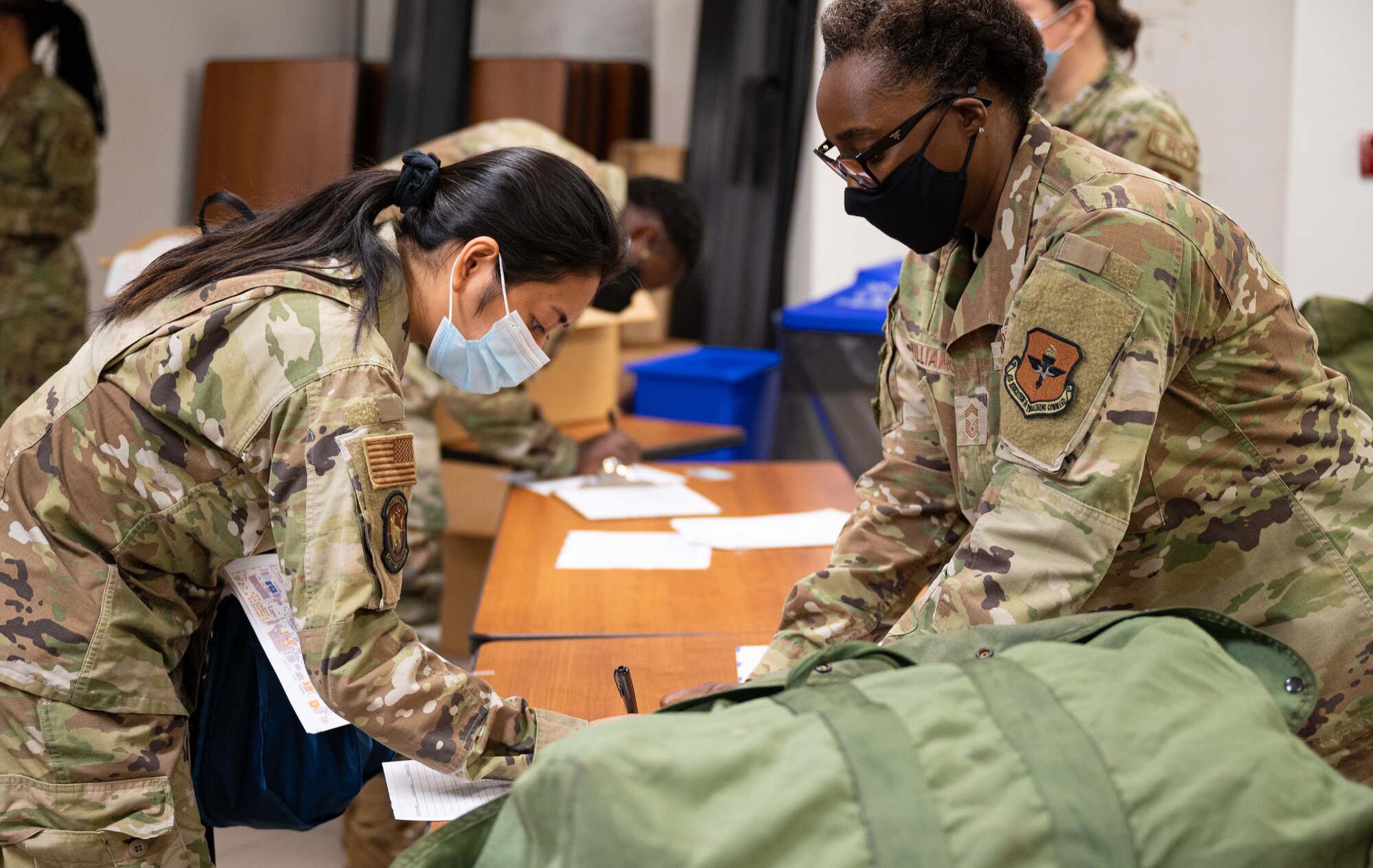 U.S. Air Force Chief Master Sgt. Felicia Williams, right, 56th Logistics Readiness Squadron chief enlisted manager, issues individual protective gear to an Airman assigned to the 56th Fighter Wing Aug. 30, 2021, at Luke Air Force Base, Arizona. More than 70 Luke AFB Airmen deployed to Holloman AFB, New Mexico, in support of Operation Allies Welcome. The operation supports the temporary provision of medical screening, lodging, and other general support for Afghan evacuees and their families arriving to several military installations in the United States. (U.S. Air Force photo by Senior Airman Leala Marquez)