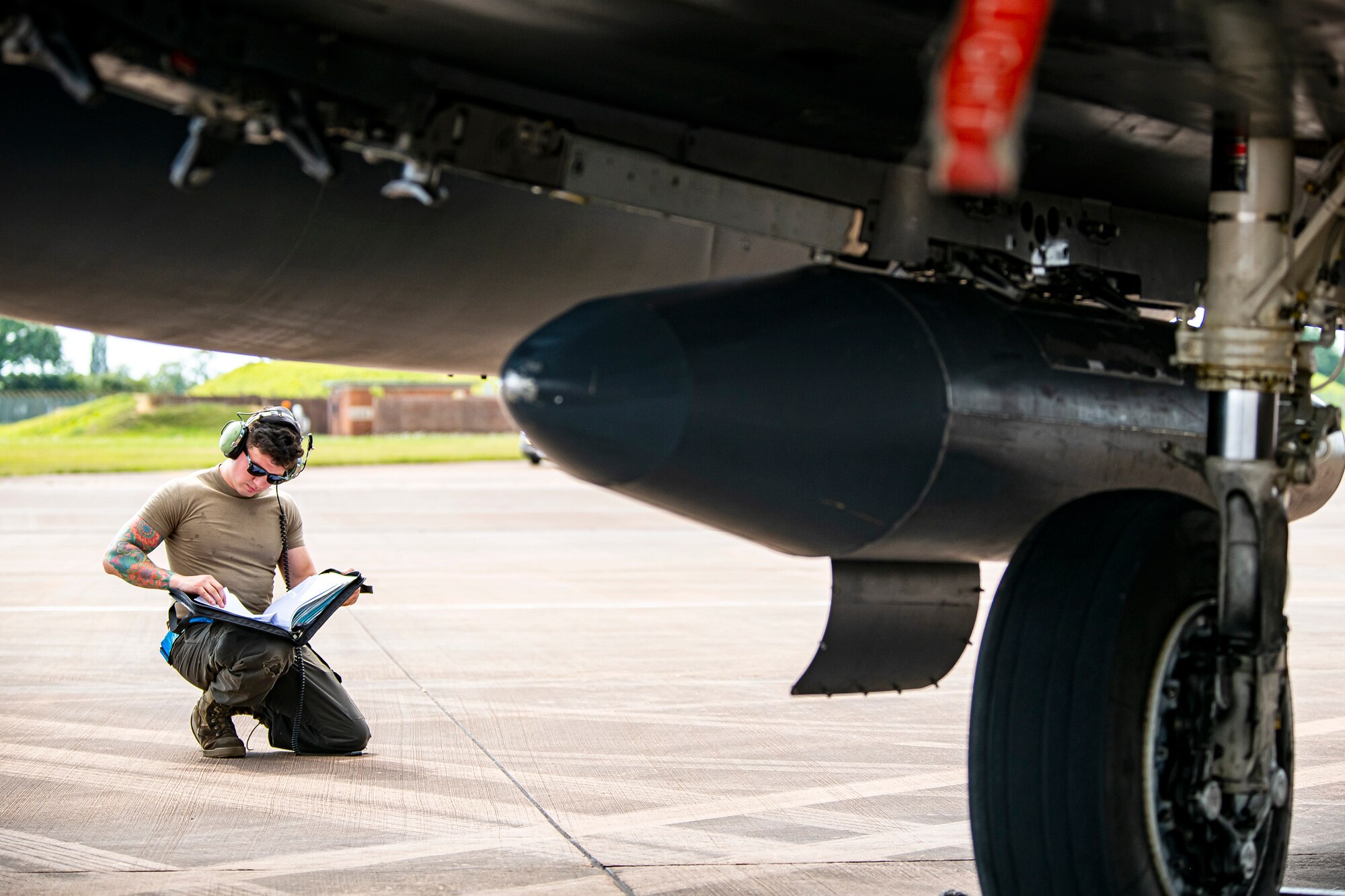 Senior Airman Steven Guerra, 48th Aircraft Maintenance Squadron crew chief, reads a technical order during an Agile Combat Employment exercise at RAF Fairford, England, Aug. 23, 2021. Utilizing ACE concepts ensures that U.S. forces in Europe are better equipped to operate from locations with varying levels of capacity and support to accomplish the mission. This further ensures Airmen and aircrews are postured to deliver lethal combat power across the full spectrum of military operations. (U.S. Air Force photo by Senior Airman Eugene Oliver)