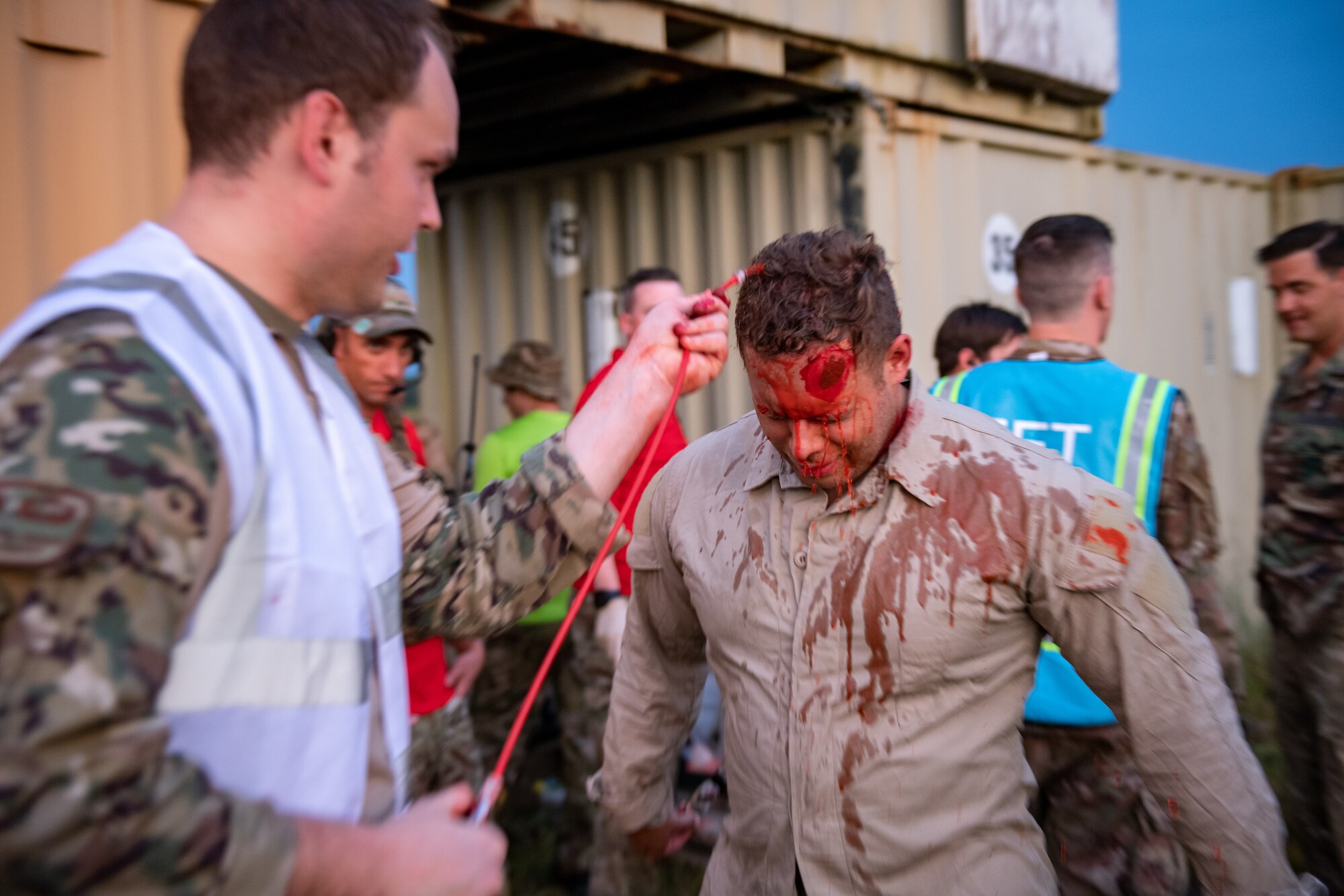 Photo of Airman applying moulage to another Airman