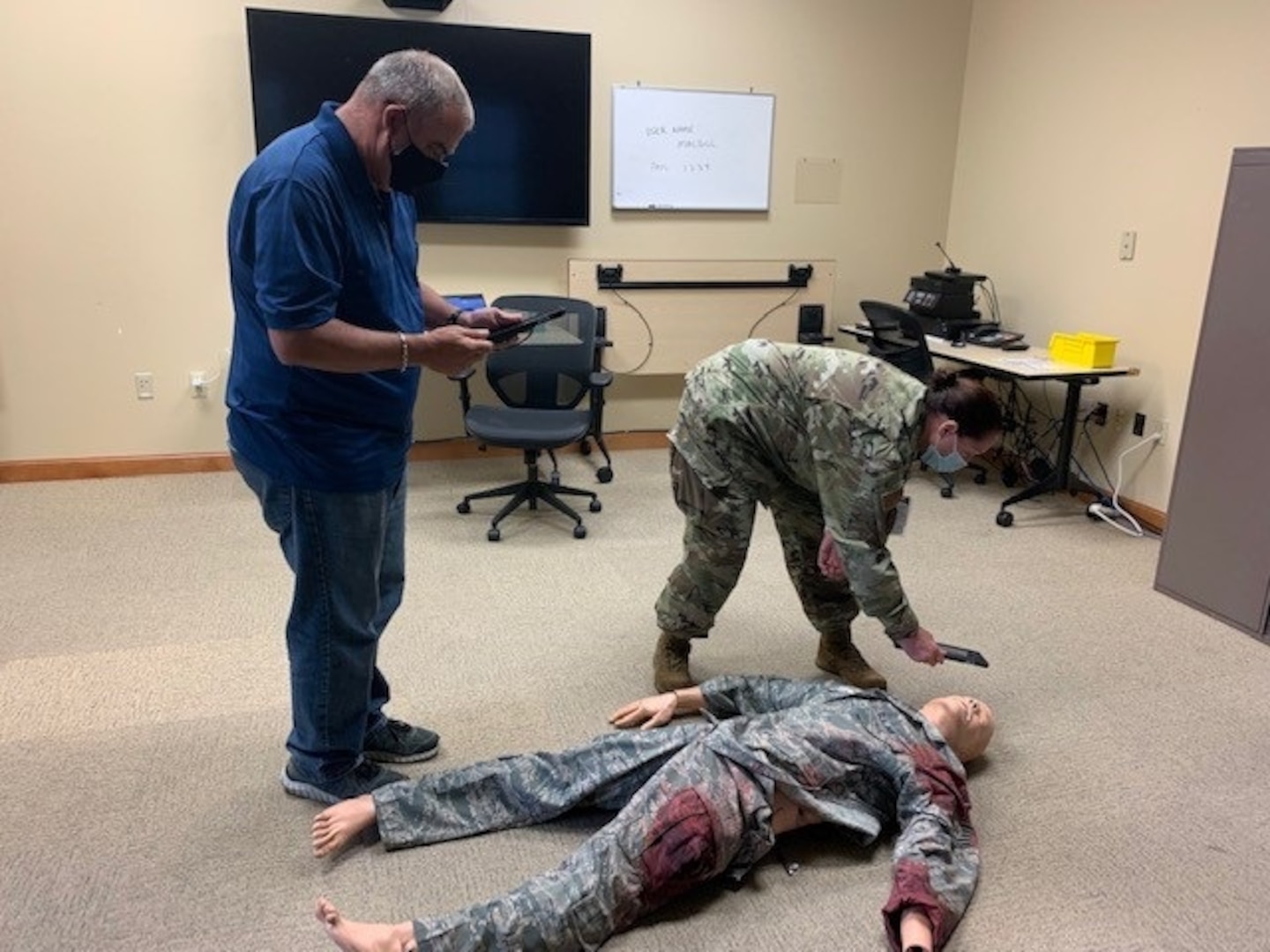Richard Cook, left, assigned to the 6th Medical Group Education and Training Flight, directs a student in augmented reality medical care of a simulated patient at MacDill Air Force Base, Florida, Aug. 3, 2021. The introduction of augmented reality training increases the availability of training, without a need to increase manpower availability for training setup and multiple student face-to-face interaction. (Courtesy photo)