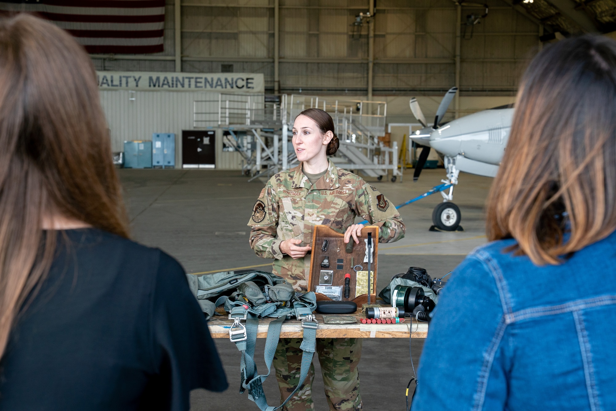 U.S. Air Force Senior Airman Lauren Whitman, a 3rd Operations Support Squadron aircrew flight equipment technician, briefs 3rd Wing spouses during an immersion tour at Joint Base Elmendorf-Richardson, Alaska.