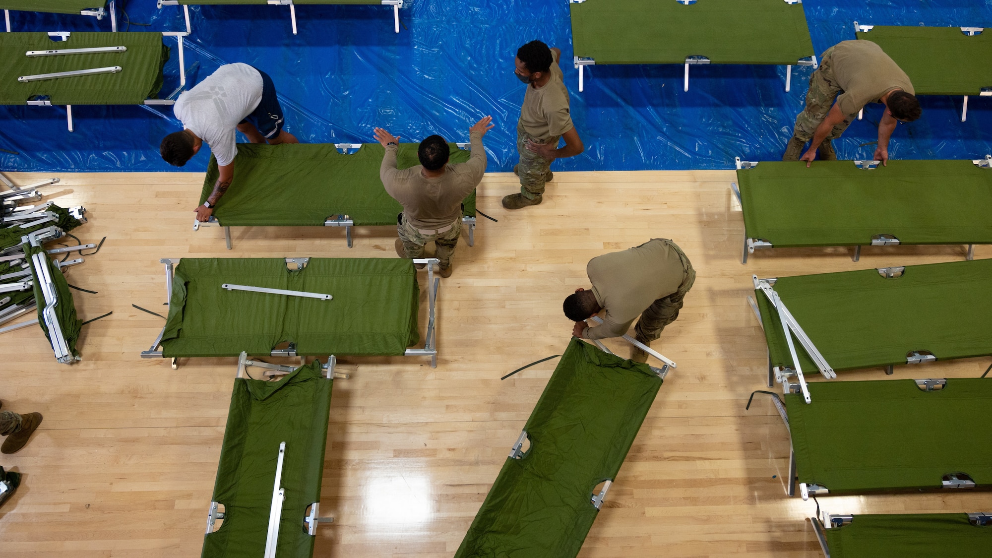 49th Force Support Squadron personnel and volunteers unpack and set up cots for Task Force-Holloman personnel Aug. 27, 2021 on Holloman Air Force Base, New Mexico. The Department of Defense, through U.S. Northern Command, and in support of the Department of Homeland Security, is providing transportation, temporary housing, medical screening, and general support for up to 50,000 Afghan evacuees at suitable facilities, in permanent or temporary structures, as quickly as possible. This initiative provides Afghan personnel essential support at secure locations outside Afghanistan. (U.S. Air Force photo by Tech. Sgt. BreeAnn Sachs)