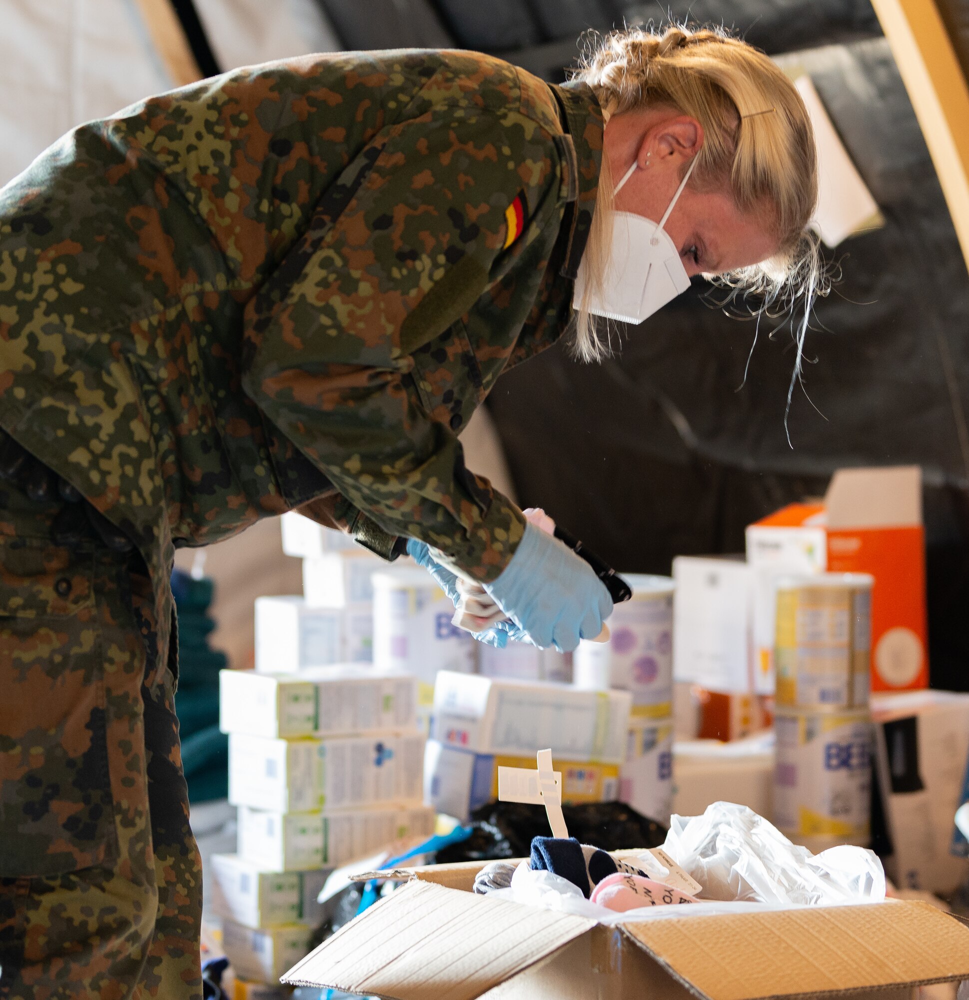 German military member sorts through donations.
