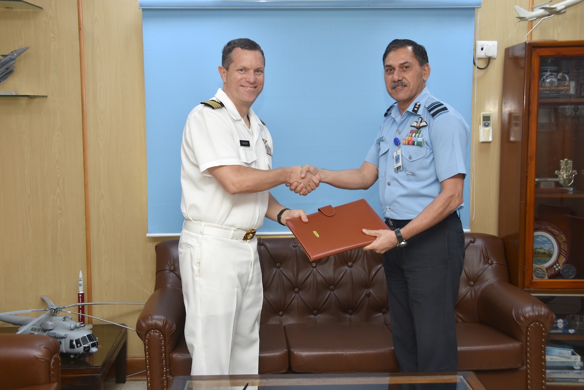 U.S. Navy Capt. Michael Farmer, left, chief, Office of Defense Cooperation, New Delhi, shakes hands with Indian air force Air Vice Marshal Narmdeshwar Tiwari, right, assistant chief of Air Staff for Plans, after Tiwari countersigns an   agreement to co-develop air-launched unmanned aerial vehicles under the U.S.-India Defense Technology and Trade Initiative, at Indian Air Force headquarters in New Delhi, India, July 30, 2021. The Air Force Research Laboratory stood up a new Strategic Partnering Directorate, or AFRL/SP, to better achieve the Department of the Air Force’s mission and vision of collaborative science and technology partnerships. AFRL/SP will now manage international partnerships for the laboratory. (U.S. Air Force photo)