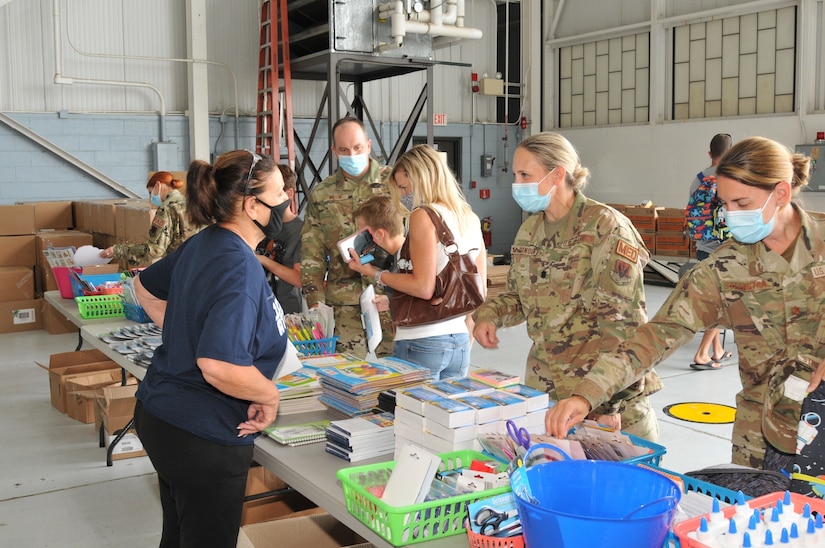 Anna Richar, 111th Attack Wing’s Airman & Family Readiness Group program manager, assists Lt. Col. Angela McDonough of the 111th Medical Group during the Backpack Brigade,  an annual school supply collection and distribution campaign, held at Biddle Air National Guard Base in Horsham, Pennsylvania, August 8, 2021. 111th ATKW’s Family Readiness Group has distributed more than 300 backpacks to military children to offset the cost of school expenses for military families. (U.S. Air National Guard photo by Tech. Sgt. Tyrone G Mitchell)