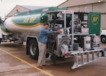 a man stands next to a fuel truck